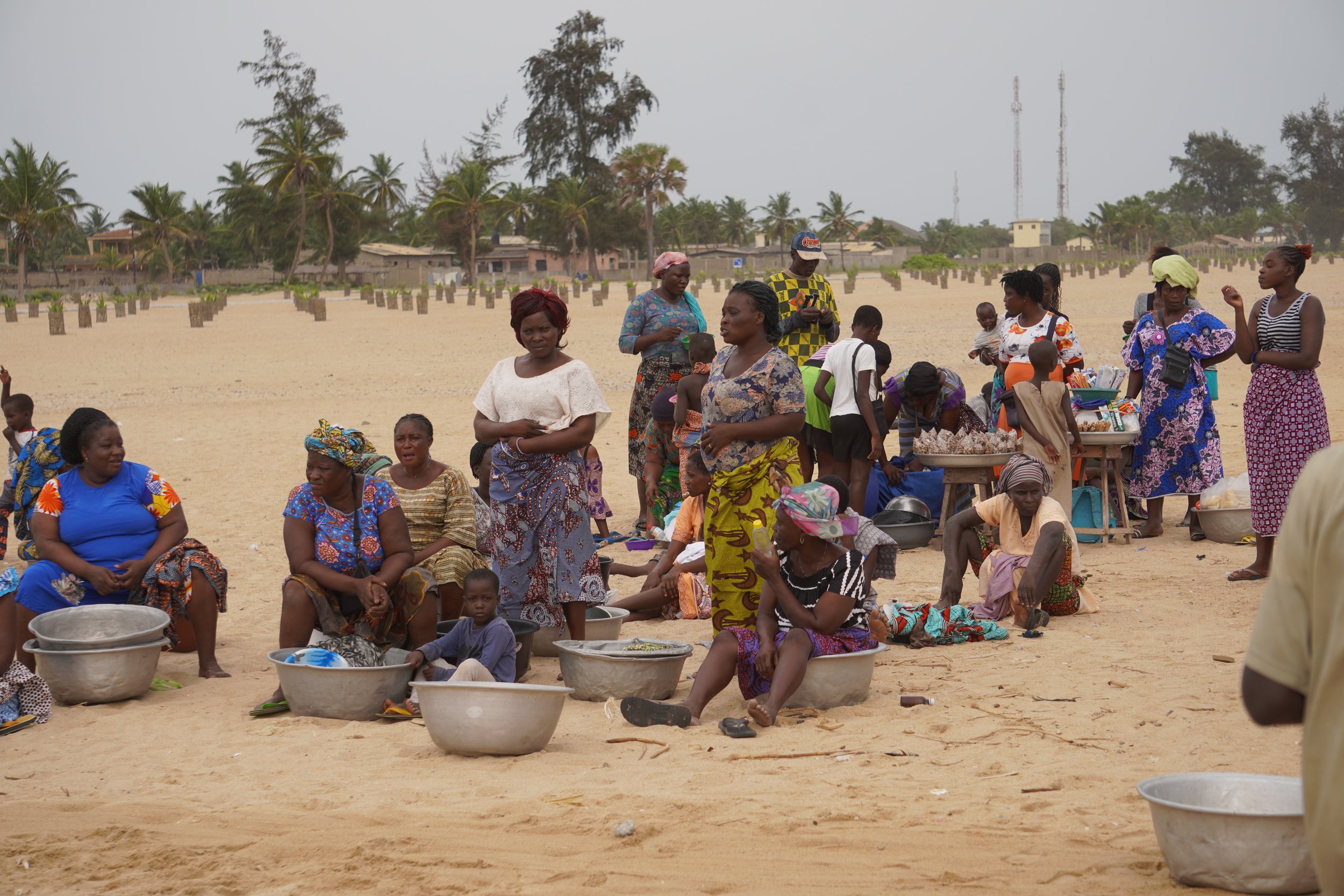  Women spread the word. They arrive towards the end and wait patiently sitting in their basins for the catch to be divided up. 