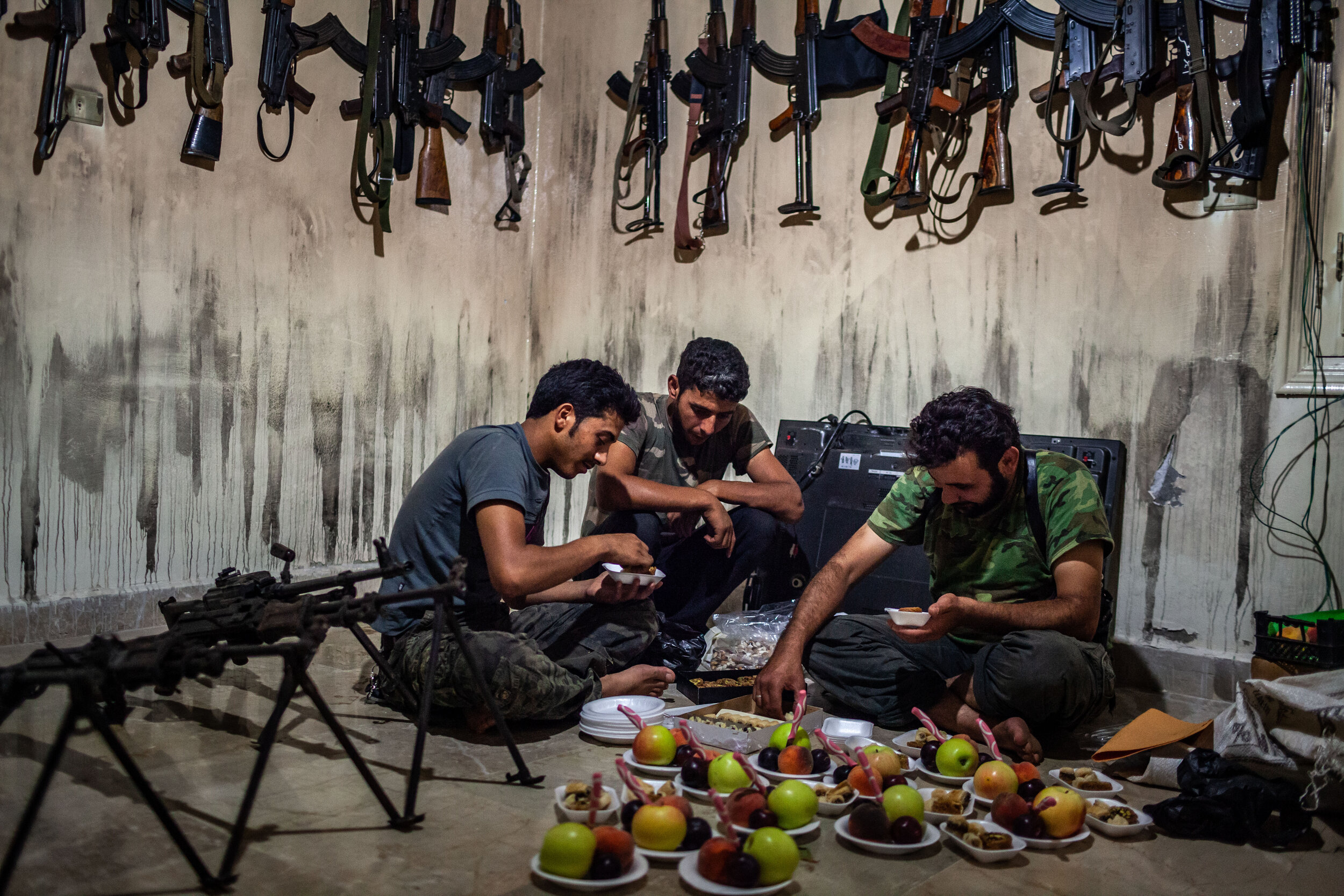  8/12/2012 Tal Rifaat, Syria: Deeb Maldaoun, 30, right, Jamal Abu Houran, 29, center, and Ahmad Aanzi, 19, left, of the Lions of Tawhid unit of the Free Syrian Army prepared fruit plates for their fellow fighters, in the groups weapons storage room a