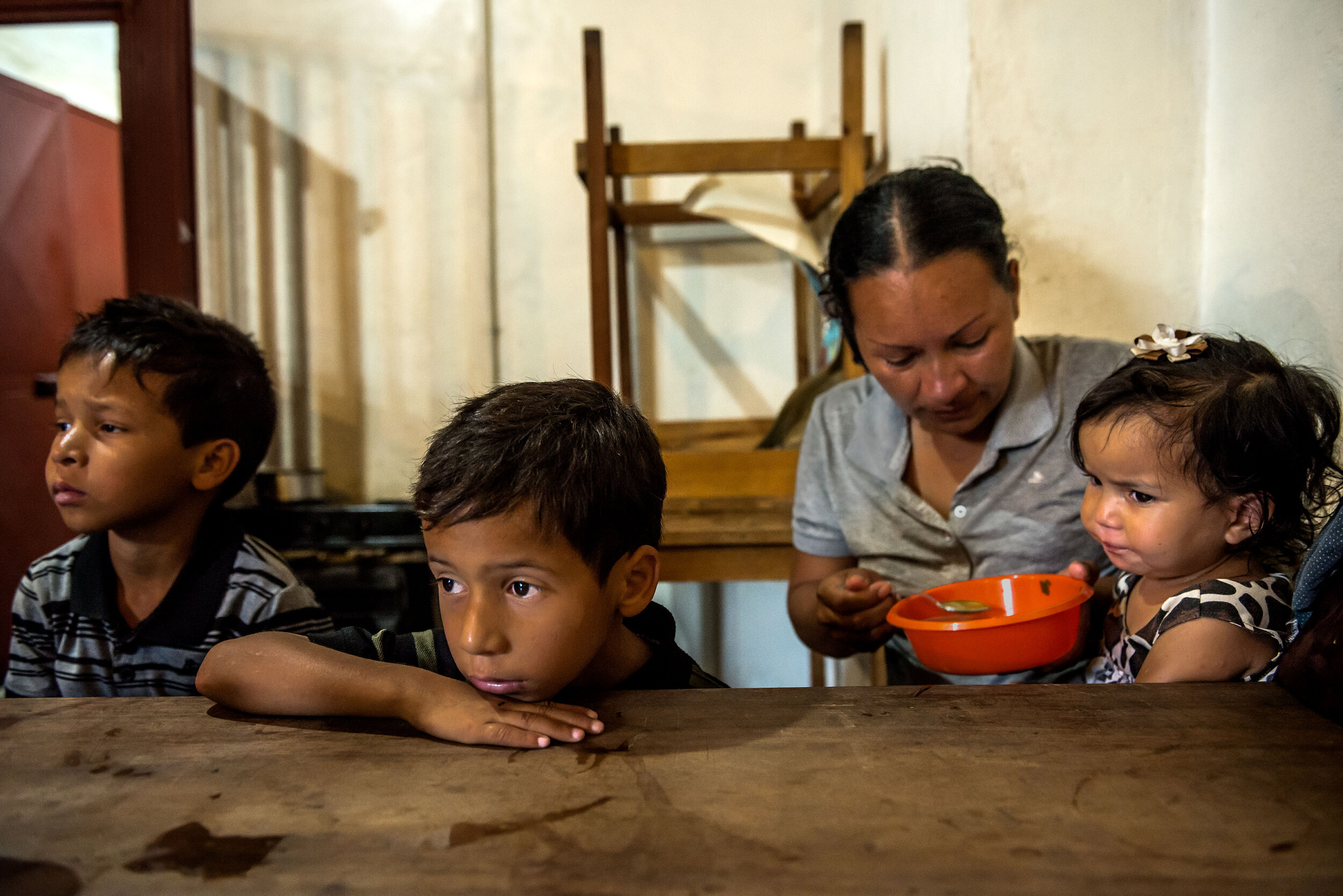  Oriana Caraballo feeds her children, Brayner, Rayman and Sofia, at a soup kitchen in Los Teques. © Meridith Kohut  