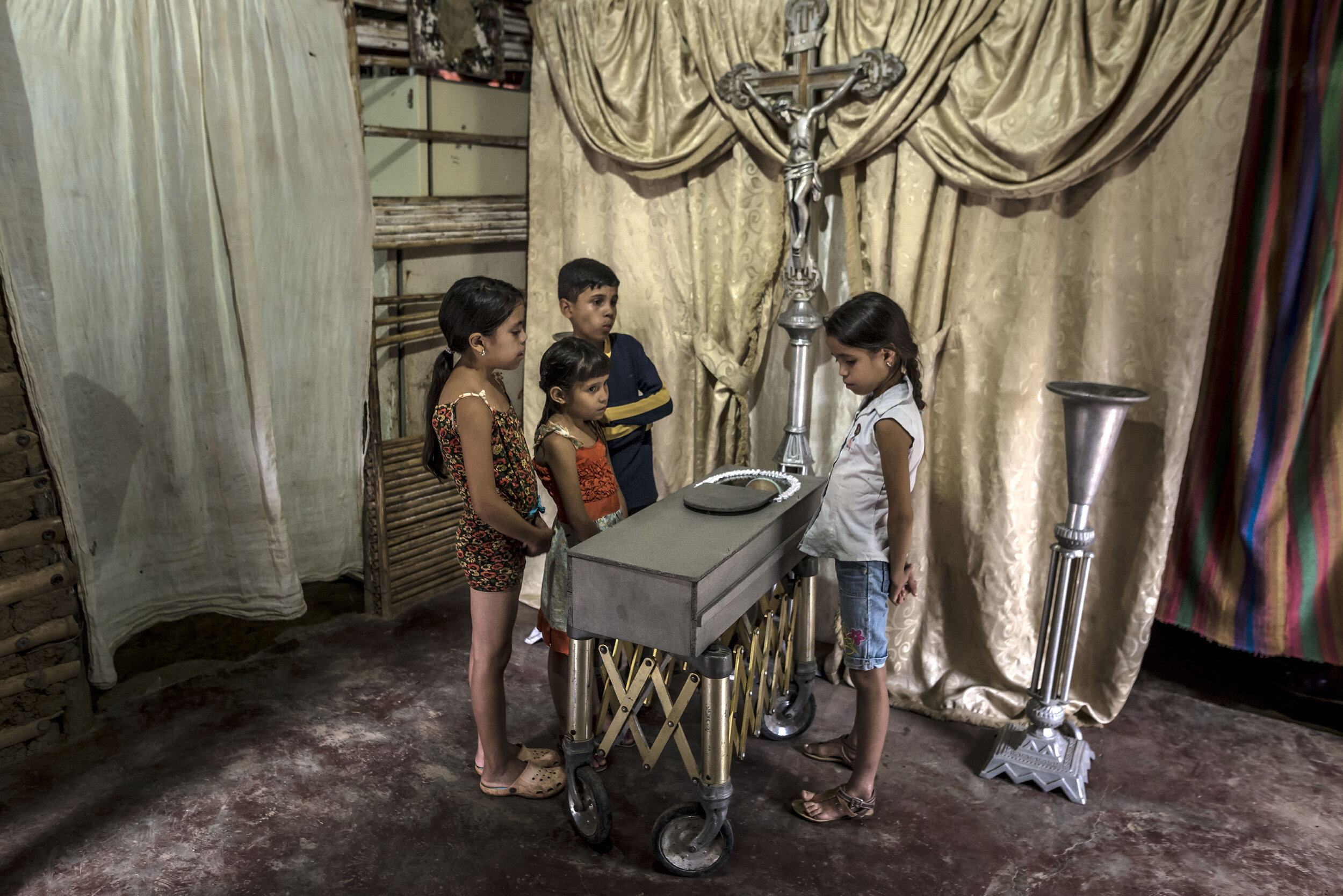  Children view the body of their 17-month old cousin, Kenyerber Aquino Merchán, who died of heart failure caused by severe malnutrition in San Casimiro, Venezeula in August 2017.  © Meridith Kohut  