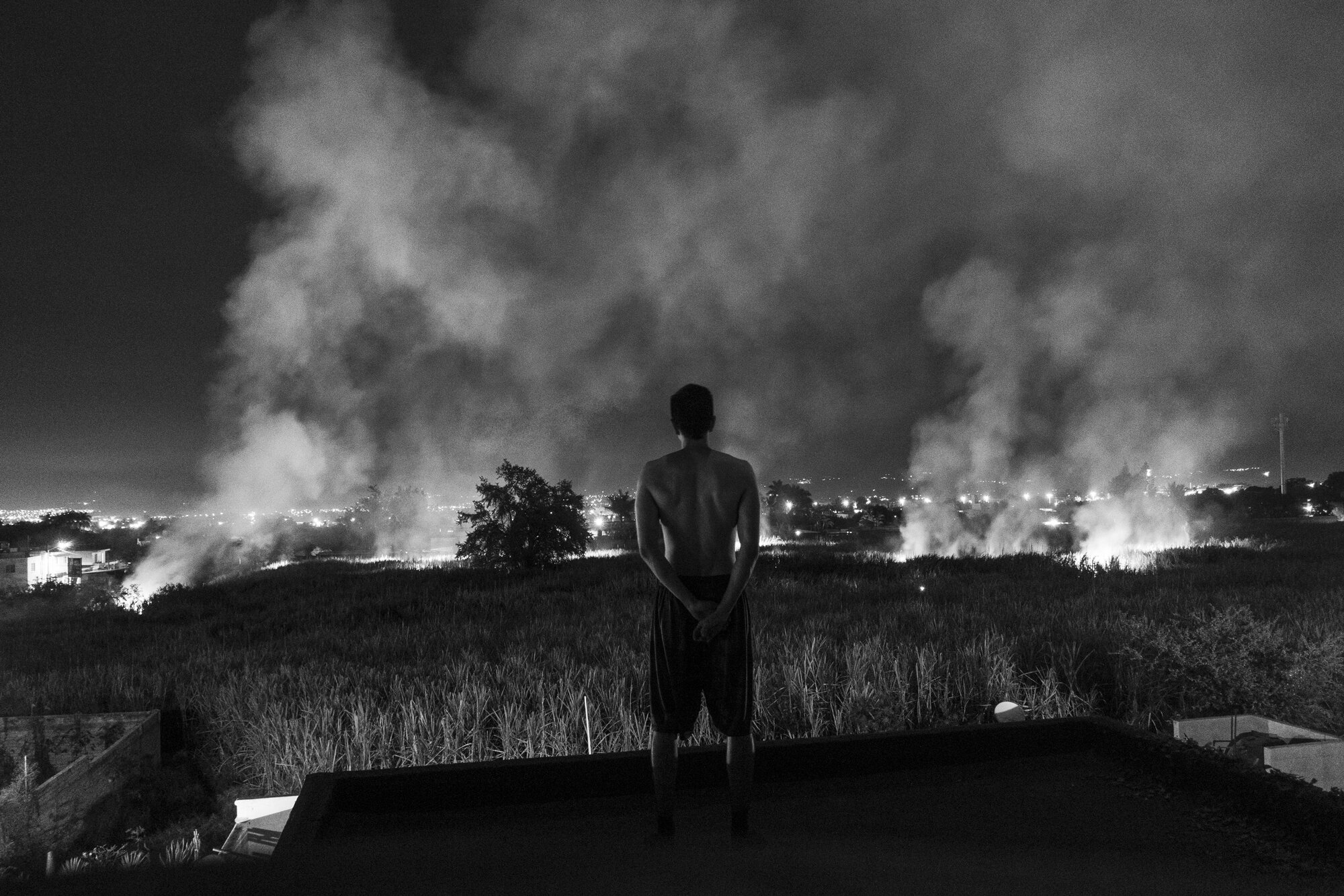  A self-portrait watching sugar cane burn. I live in Nayarit and the Mexican state has many sugar cane fields, and I have documented many of the laborers who work there. While watching the sugar canes burn I could only think how some of us have the “