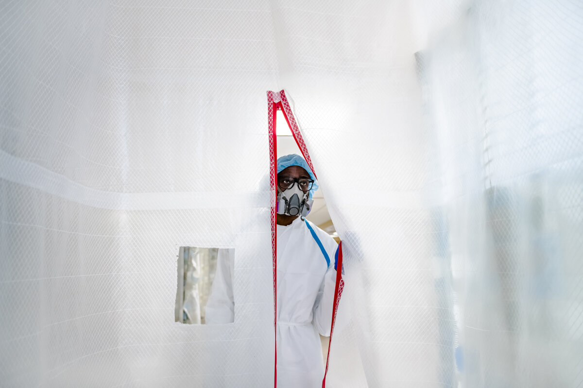  Dr. Jamar Williams peers through an improvised isolation area to check on the vitals of a Covid-19 patient in Wyckoff Heights Medical Center on April 25, 2020. “I signed up for this and I wouldn’t change that. This is what it means to be a doctor, i