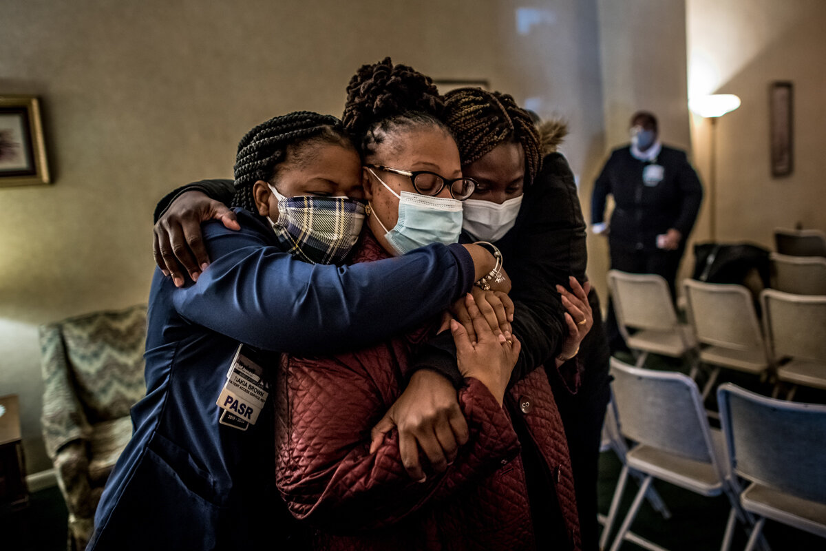  Wycoff Heights Medical Center staff members Nakia Brown, left, and Na-Keisha Baxter, right, console nurse Susan McNeil, at the funeral of Jaqueline Venner. Venner was a nurse at Wyckoff who died of Covid-19. A notice on the funeral home door discour