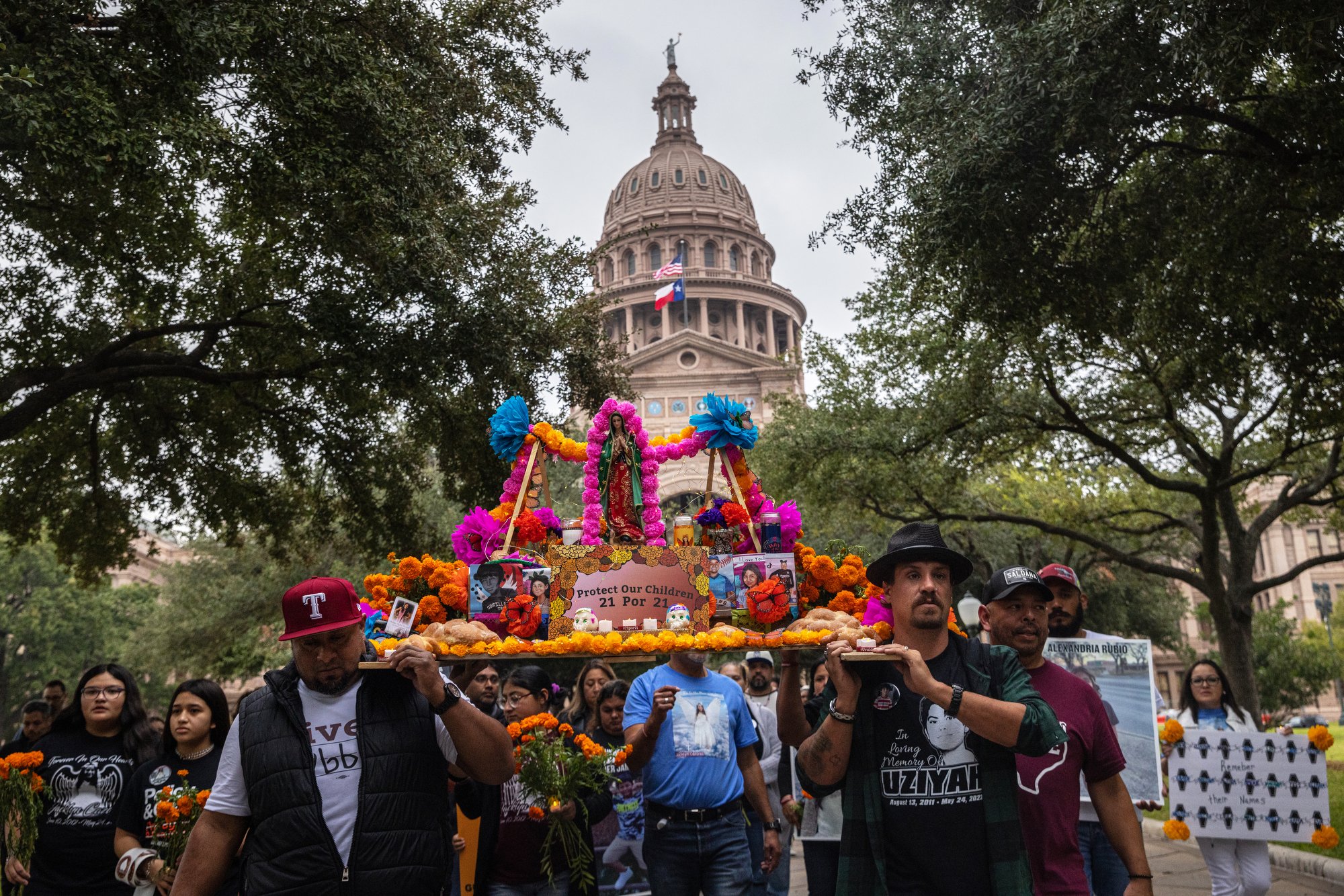  (Left to right) Orlando Mack Segovia, Brett Cross and others carry a Day of the Dead altar honoring loved ones killed in the mass shooting at Robb Elementary School in a march from the Texas State Capitol to the Governor’s Mansion in Austin, Texas, 