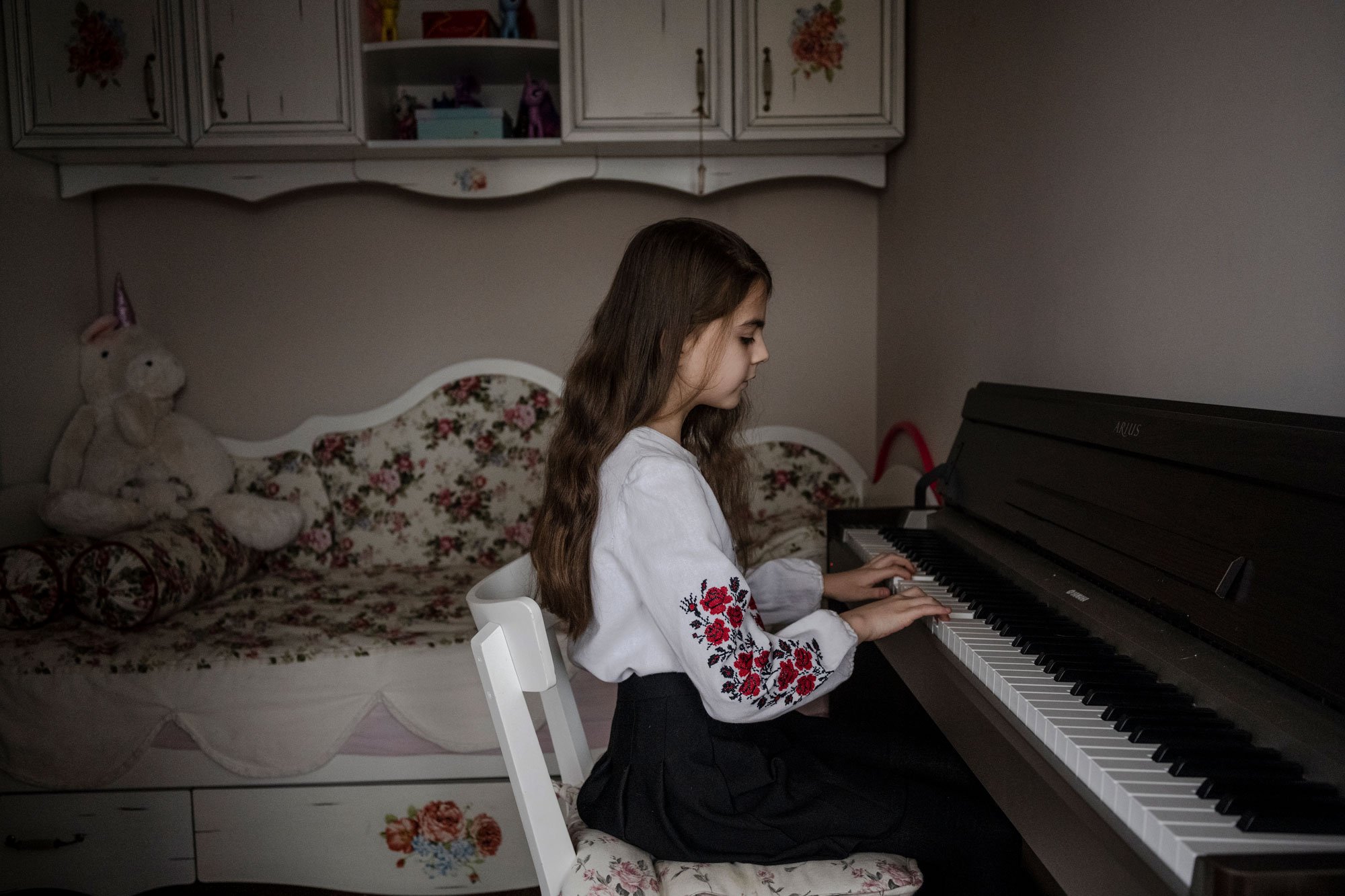  Eva Sokolenko, 9, practices on her electronic piano on Orthodox Christmas Day in Kyiv, Ukraine, January 6, 2023. In her free time after school Eva plays piano, dances, draws, paints, and practices acrobatics. 