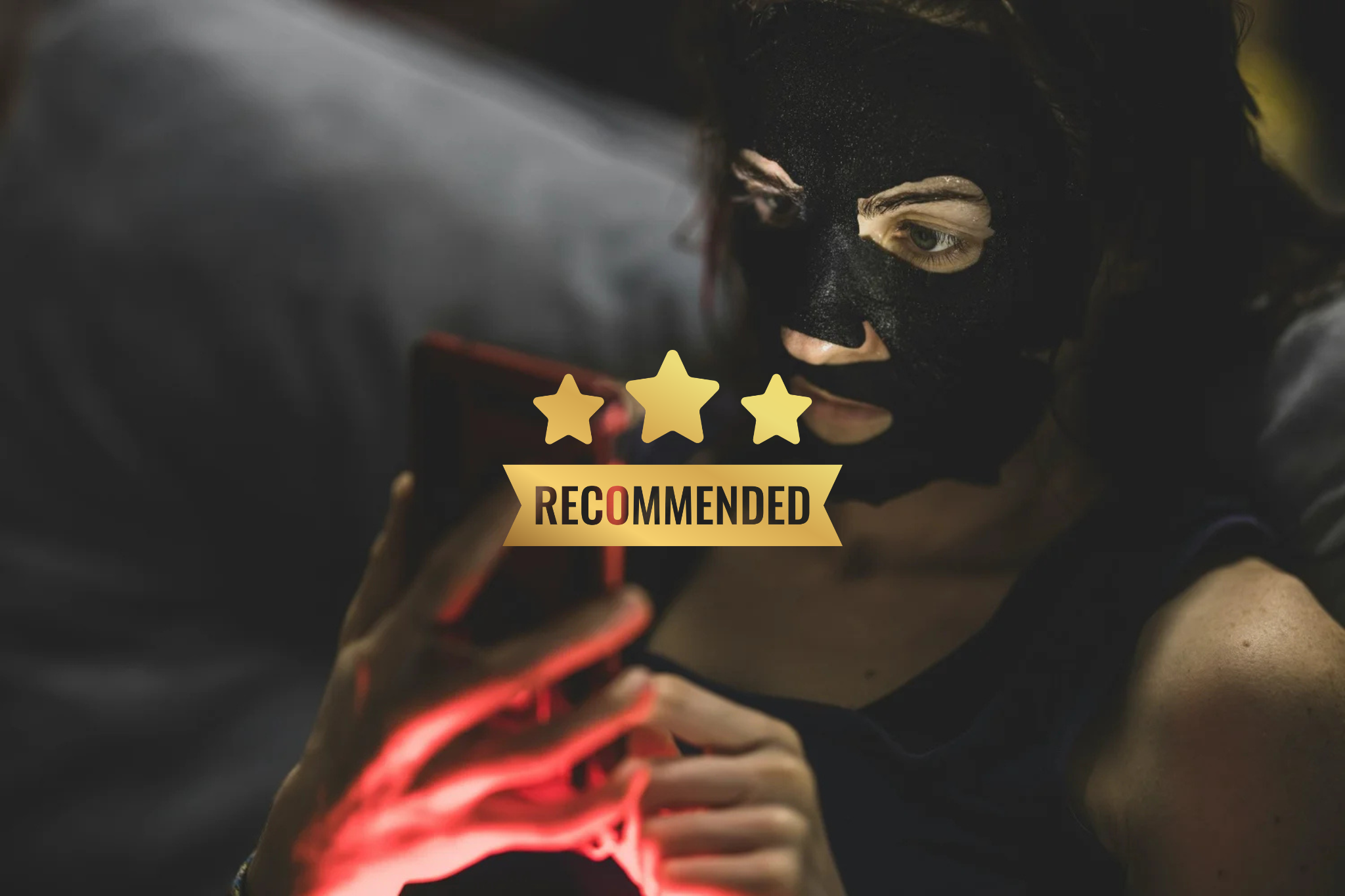 Person with dark face mask using a smartphone with a 'Recommended' badge and three stars overlayed.