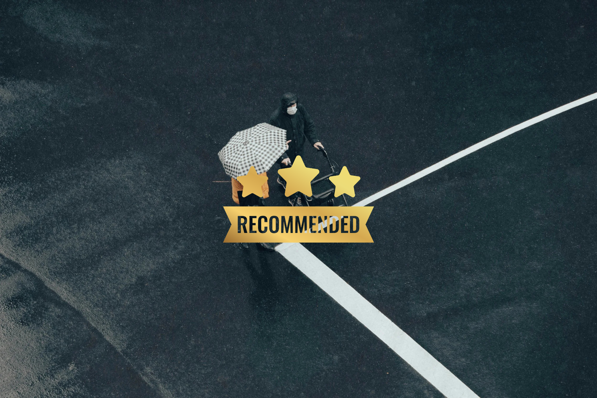 Bird's eye view of two people walking on a wet dark parking lot. One person carries an umbrella with a checkered pattern. A gold banner with the word 'RECOMMENDED' and a three-star rating overlay the image.