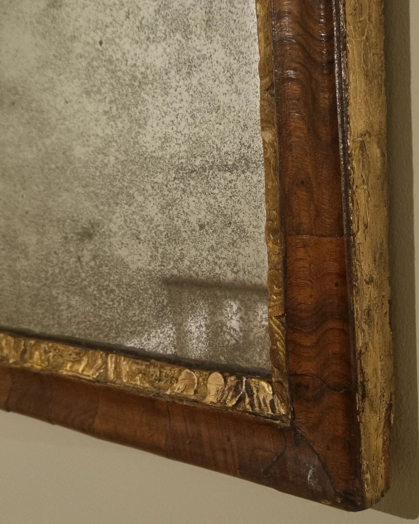 .
A small early 18th century  patinated walnut and parcel gilt mirror with the original plate.

&pound;980