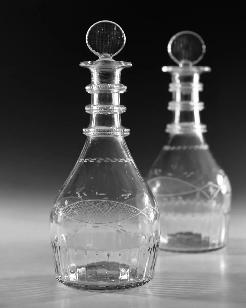 An exceptionally rare pair of Irish Regency period half size decanters with three milled neck rings, moulded basal flutes, biscuit stoppers and engraved cross hatch vesica. 

Almost certainly Cork Glass Co

Irish: Circa 1810