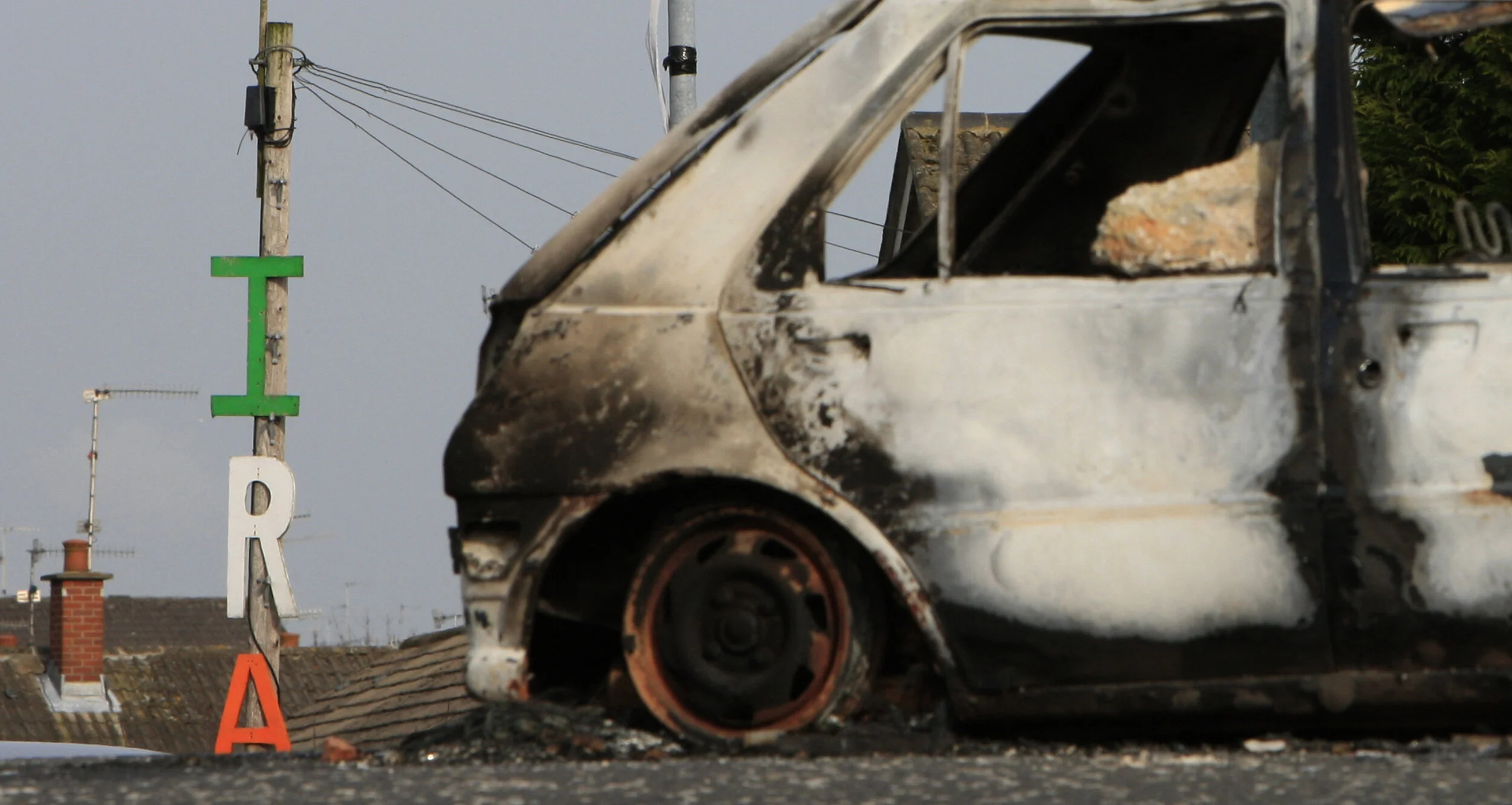 A burned out car sits on a roundabout near a IRA sign in Lurgan, Northern Ireland after a night of disturbances. 