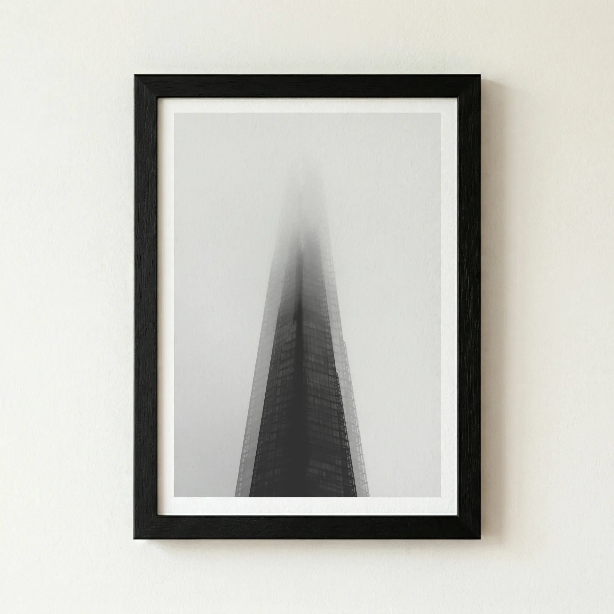 'The Dark Tower' print in a black wooden frame, enhancing the dramatic shadows and providing a bold, modern boundary for the misty London skyline.
