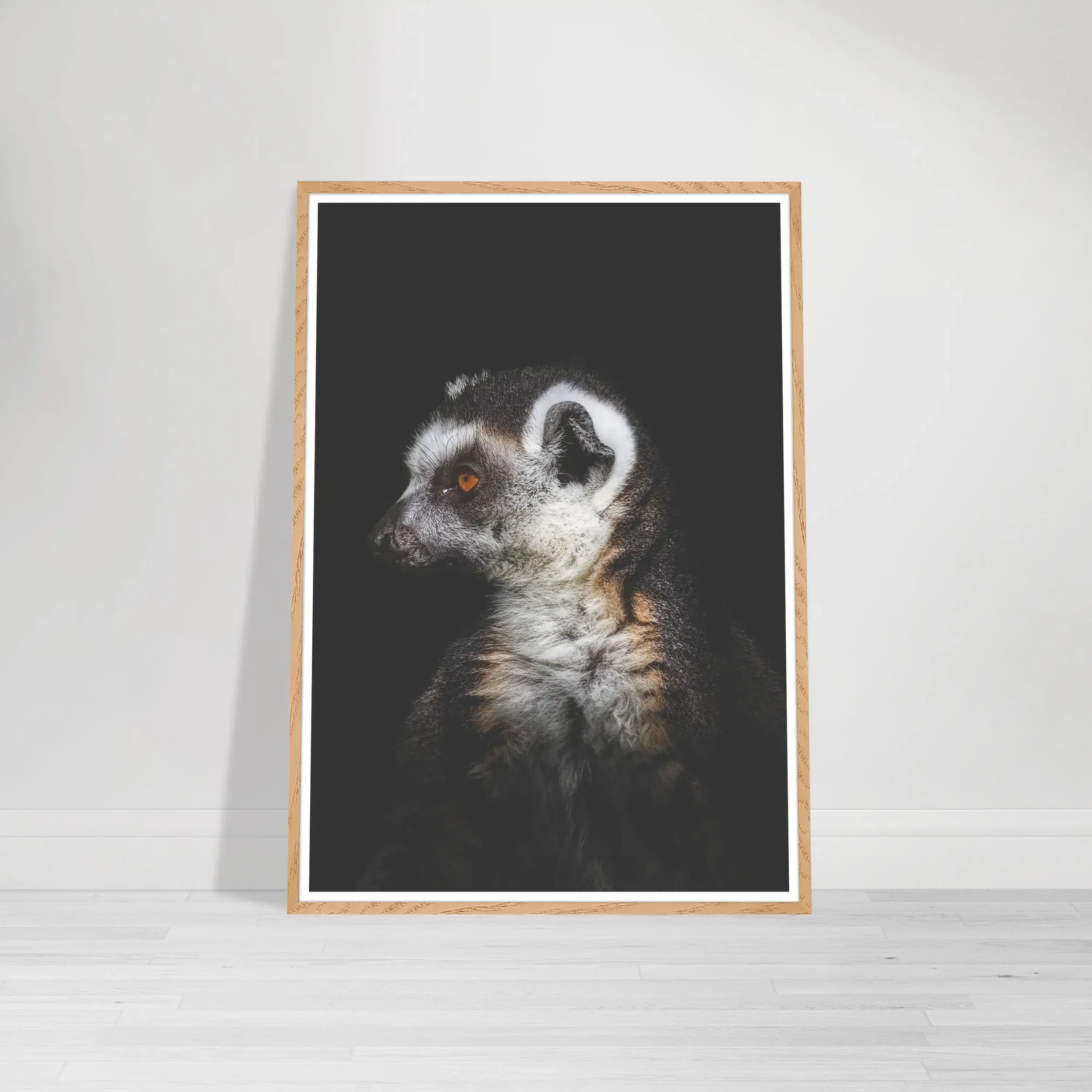 Close-up portrait of a ring-tailed lemur showing its bright eyes and striped tail in a wood frame