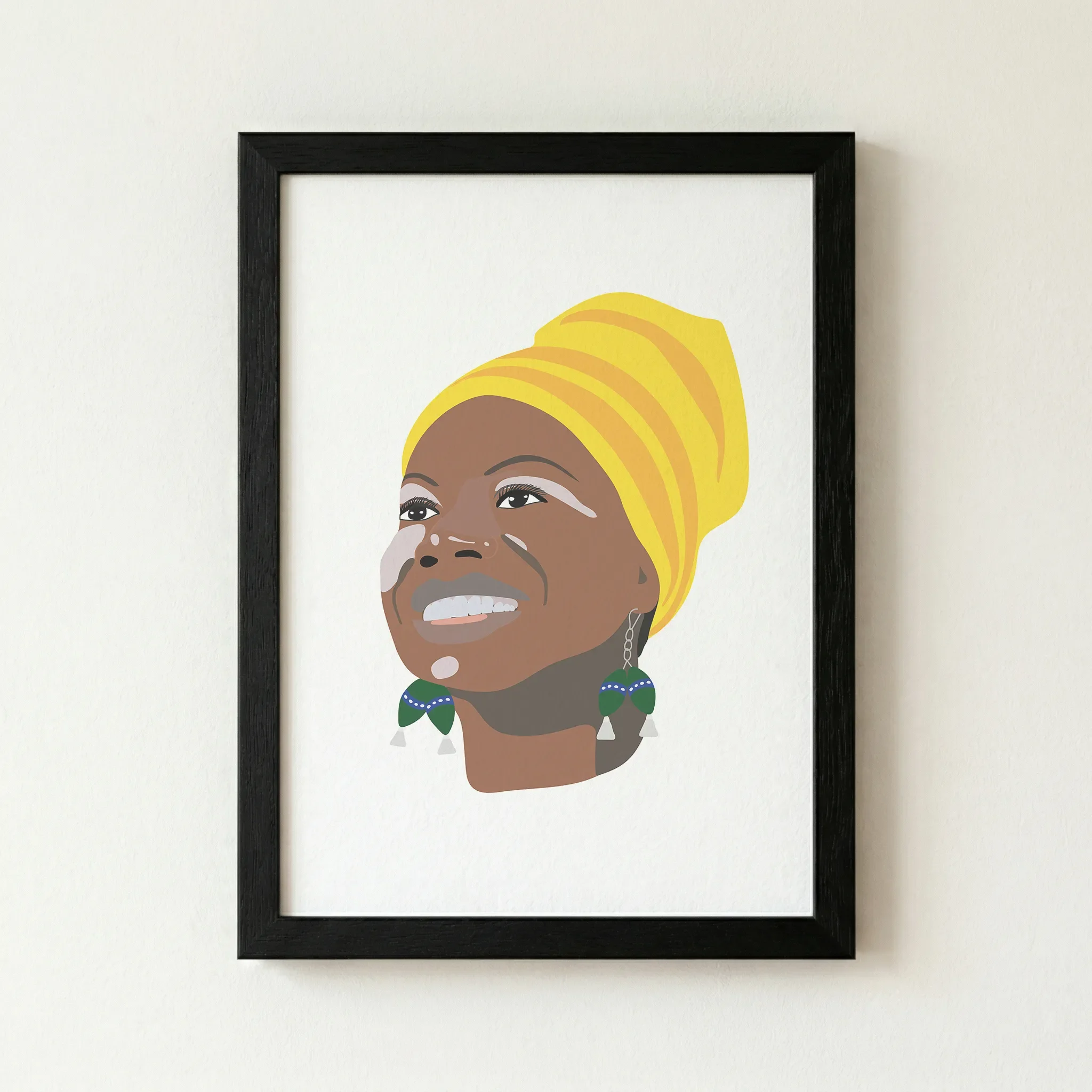 The 'Nina Simone' fine art print in a black wooden frame, providing a sharp, classic border that anchors the vibrant yellow tones of her headwrap.