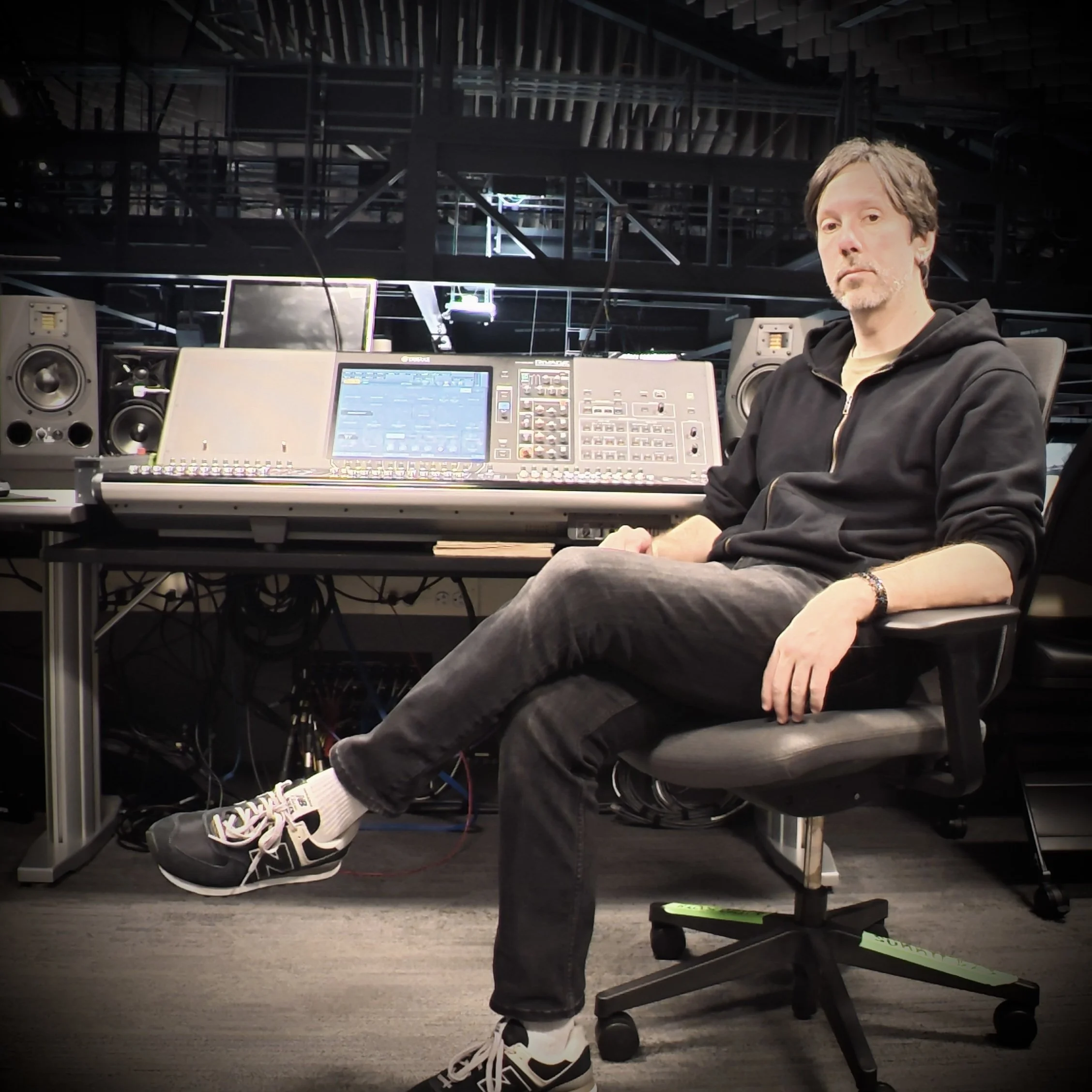David J. Nichols sitting in front of a Yamaha Rivage PM3 audio console.