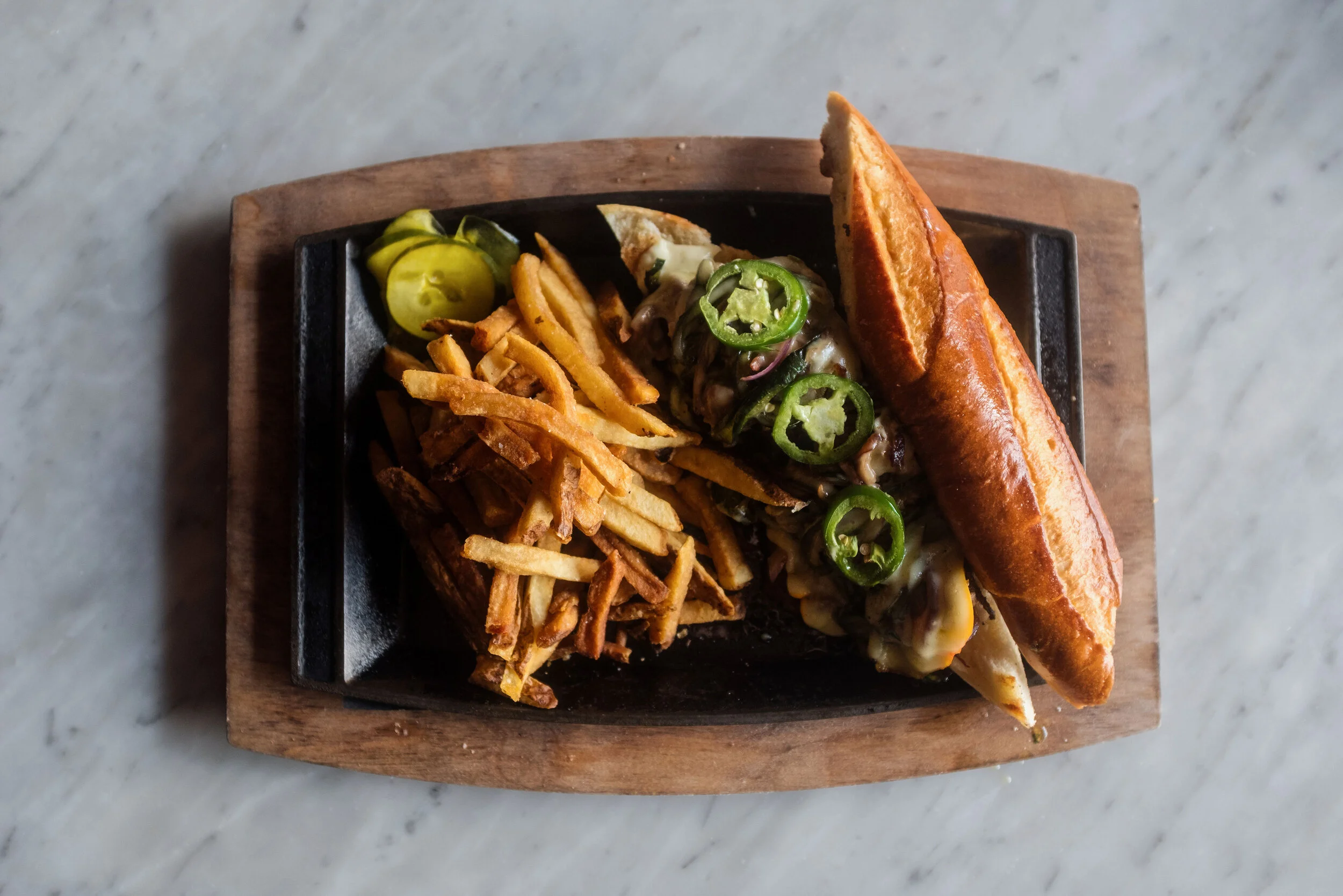 Prime Rib Sandwich | thinly sliced prime rib, griddled peppers and onions, Mahon Cheese, tarragon aioli, toasted Torpedo roll.