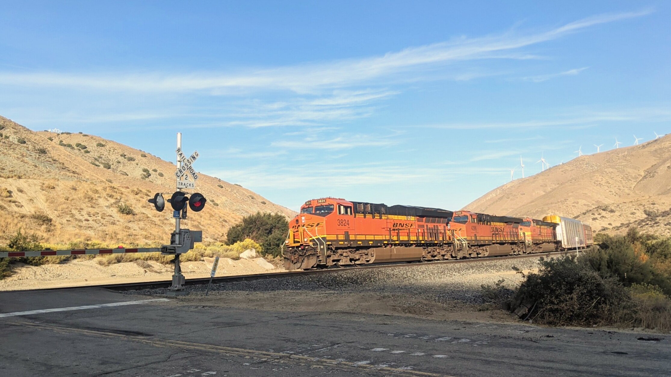  Late afternoon shadows fall across a BNSF manifest as it charges through the Tehachapi Wind Farms near Cameron, CA. Photo by Alex Lewis, 2020. 