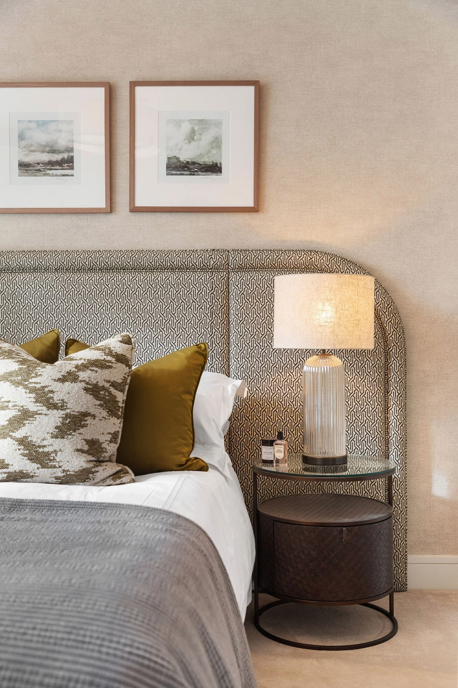 Bedroom with headboard, lamp and pops of colour added via cushions on the bed