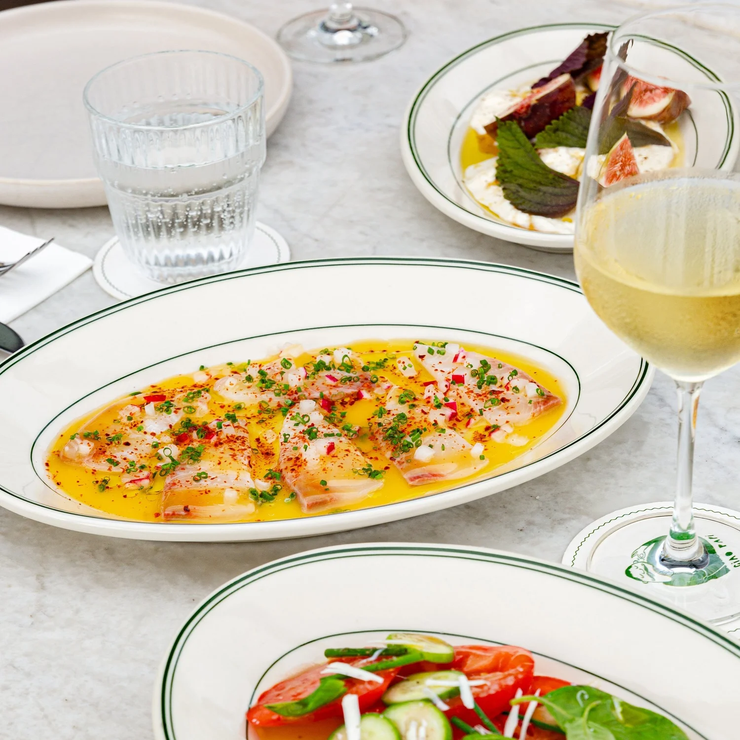 Share-style Italian feast of antipasti and pasta on a long table at Ciao