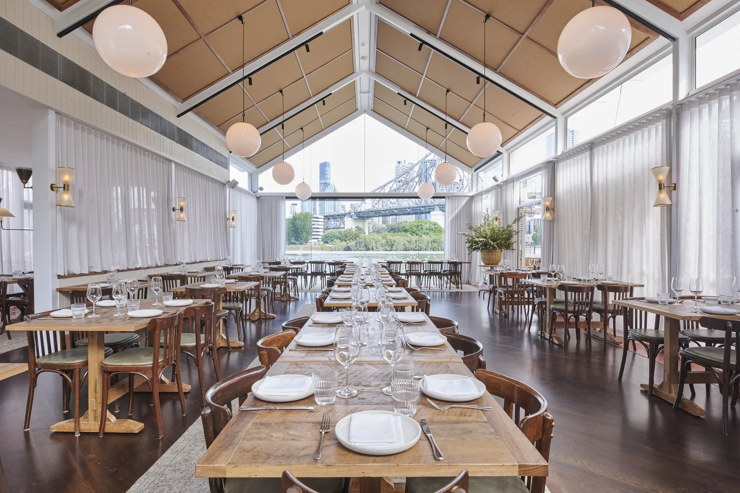 The Glass House event space at Ciao with its pitched glass roof, floor-to-ceiling windows and Story Bridge views