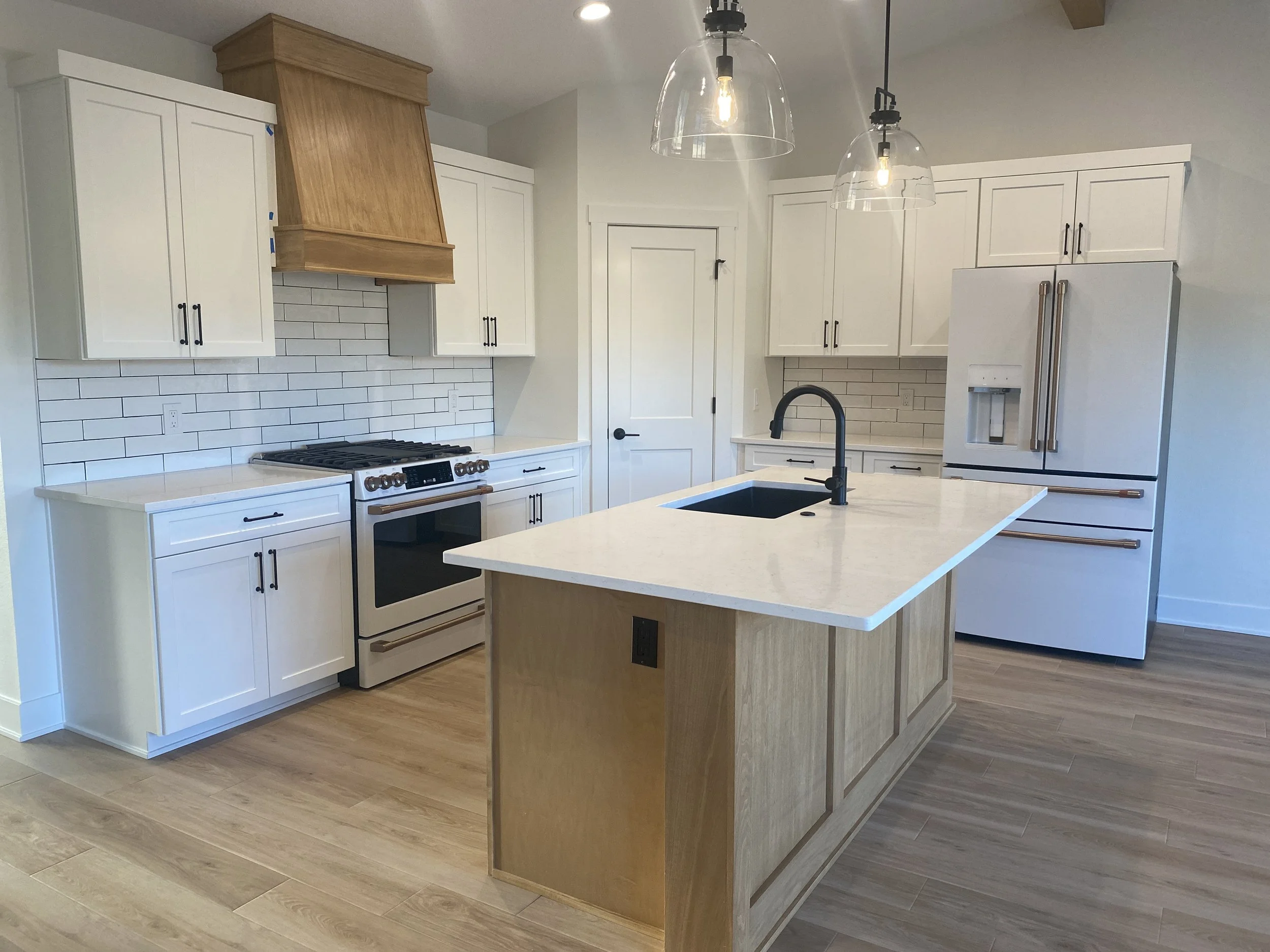 White kitchen cabinets with rye stained island & range hood. 