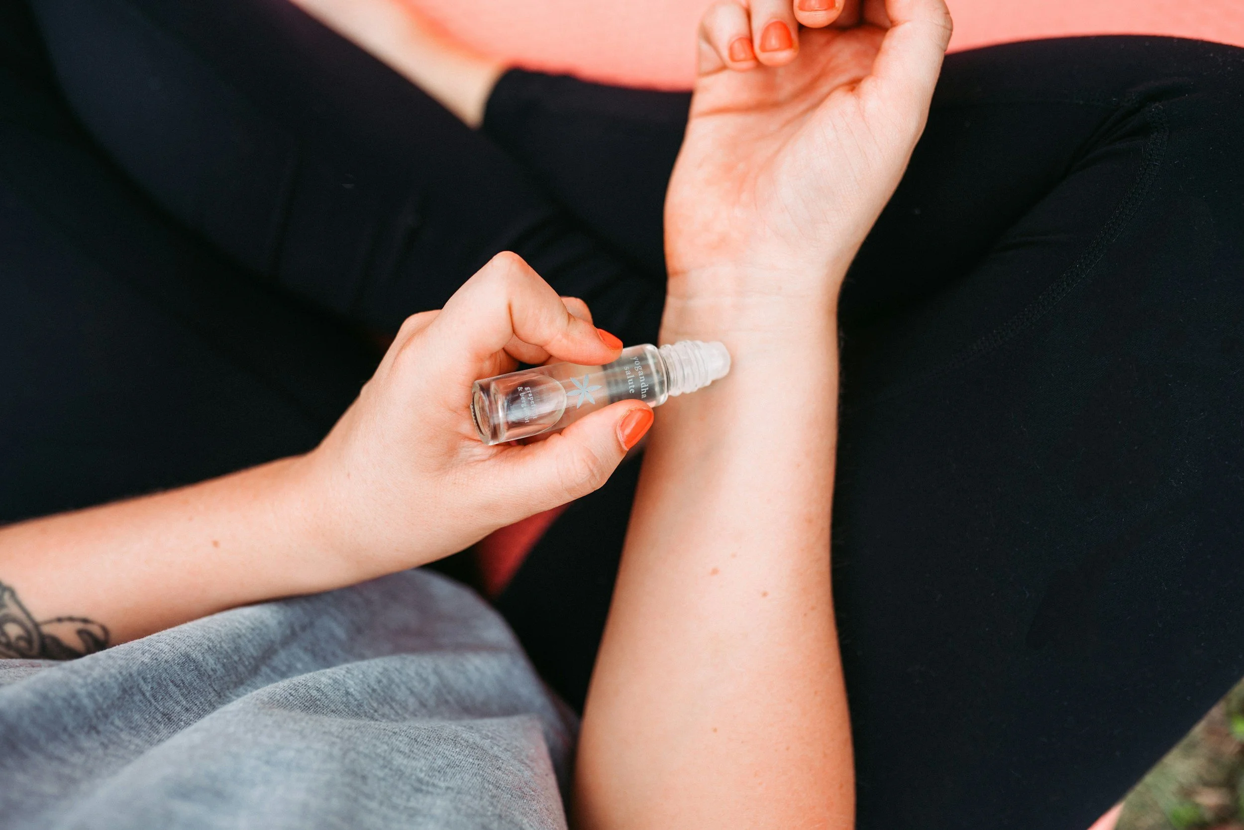 Woman applying stress and anxiety essential oil roller blend to wrist pulse points — natural aromatherapy stress relief handmade in West Cork Ireland by Wild Atlantic Wellness