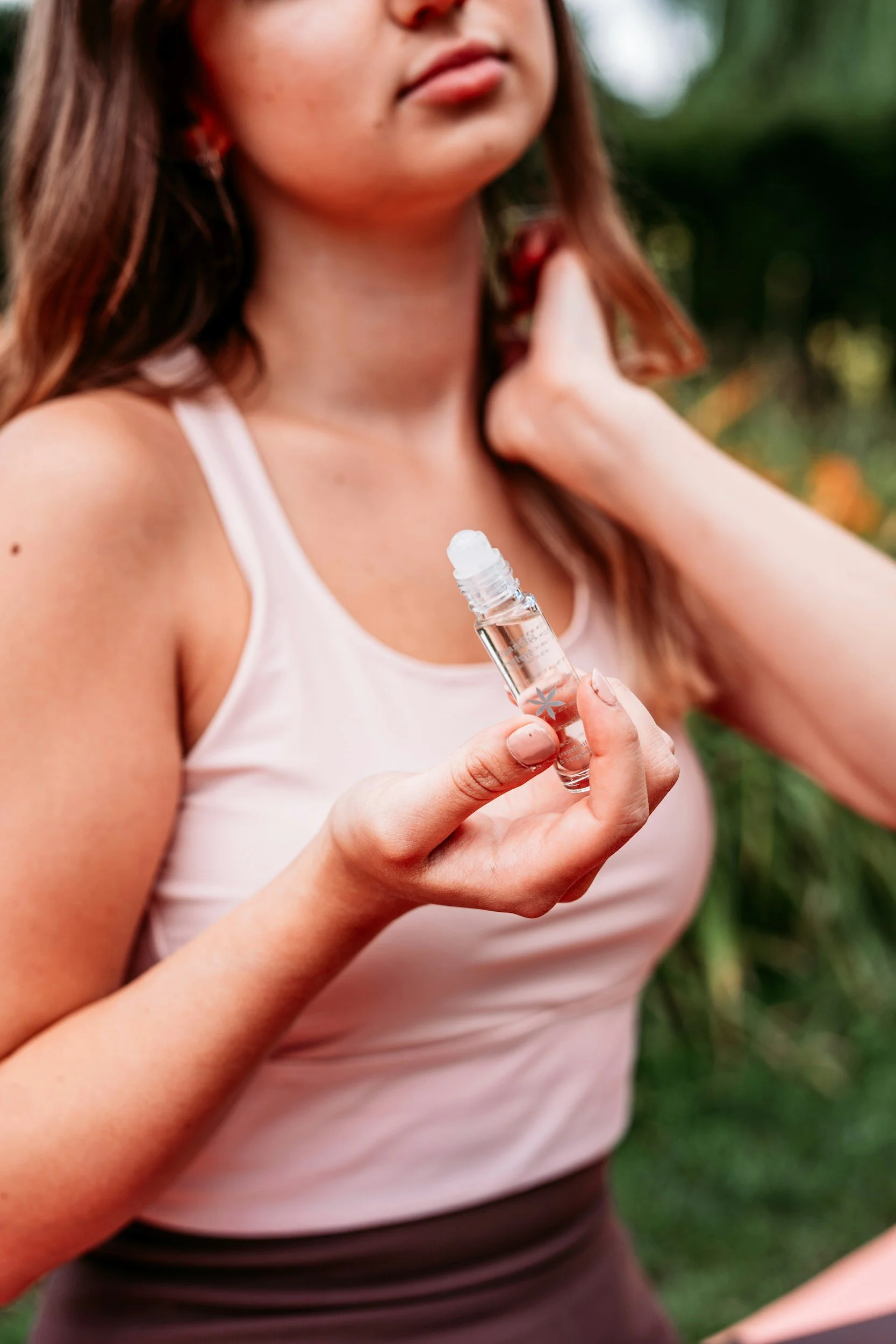 Woman applying essential oil roller blend to wrist pulse points — natural aromatherapy stress relief by Wild Atlantic Wellness West Cork Ireland