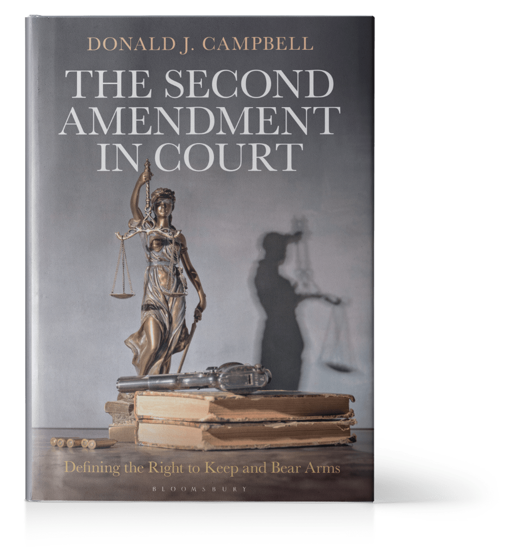 Book titled 'The Second Amendment in Court' with the subtitle 'Defining the Right to Keep and Bear Arms' by Donald J. Campbell, featuring a statue of Lady Justice on a stack of books with a shadow of the statue in the background.