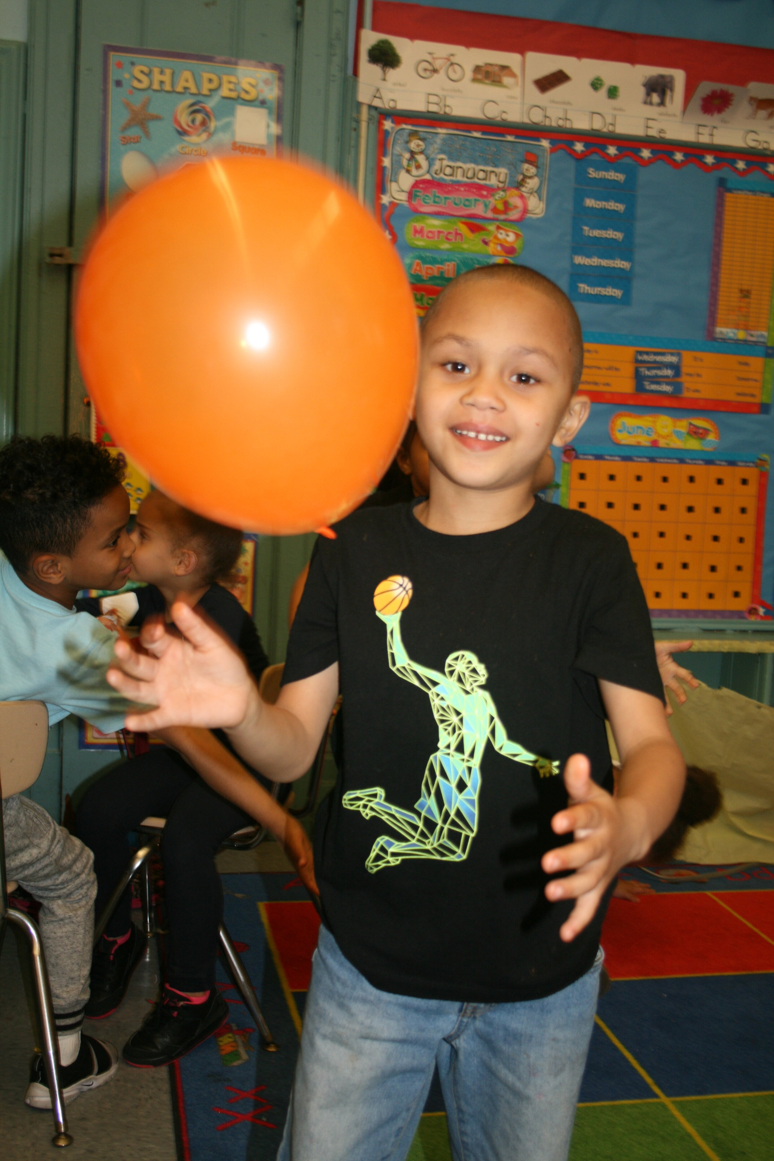 young child with orange balloon