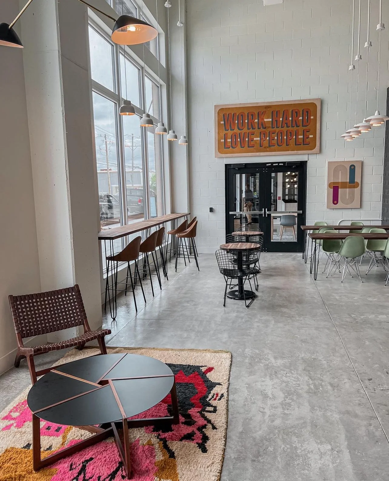 Grit Coffee - an interior view of a minimalist industrial coffeeshop with high ceilings and neutral grays and browns