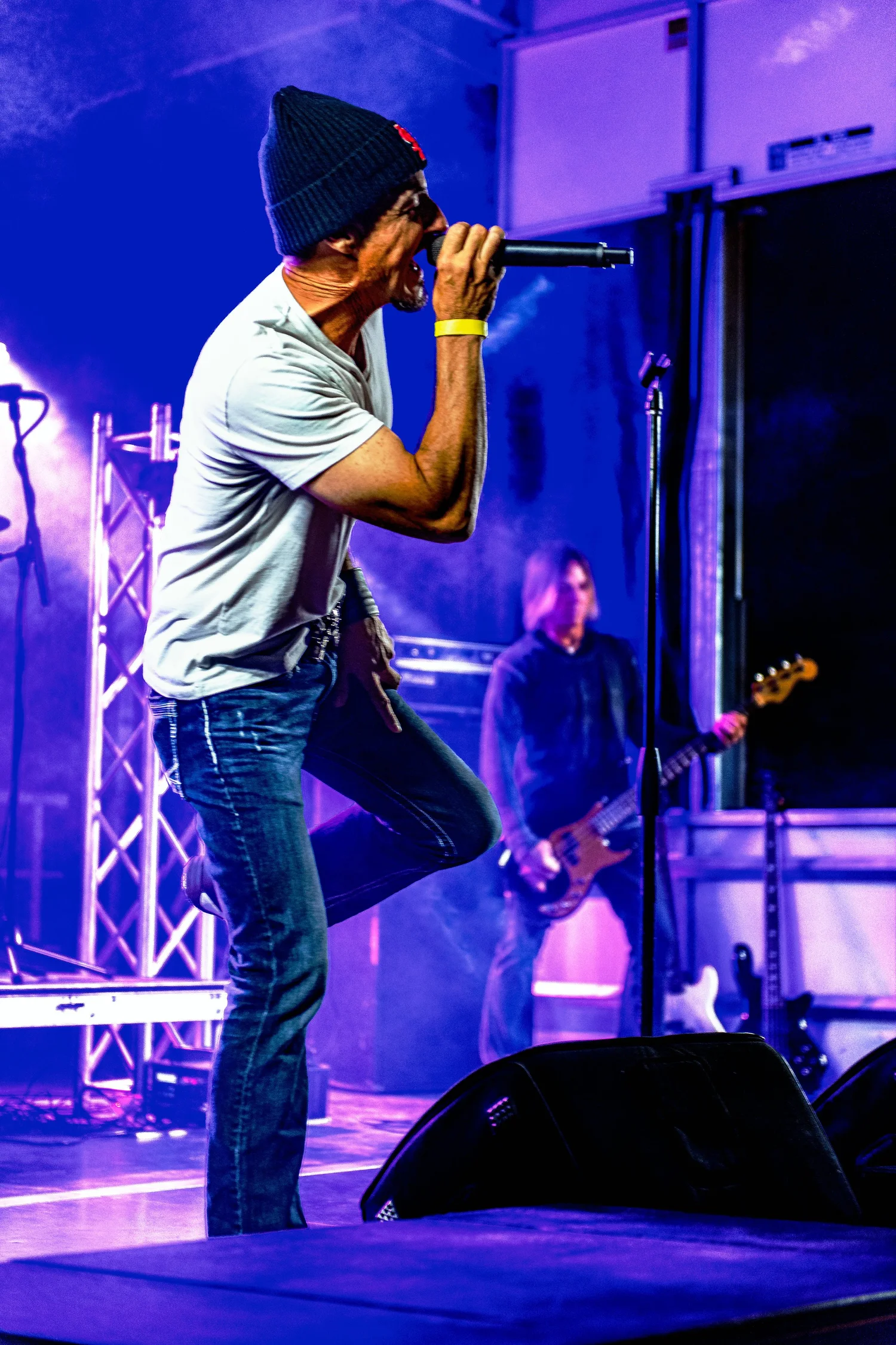 Singer Under Blue Stage Lights. Visible: singer, microphone, blue stage lighting.