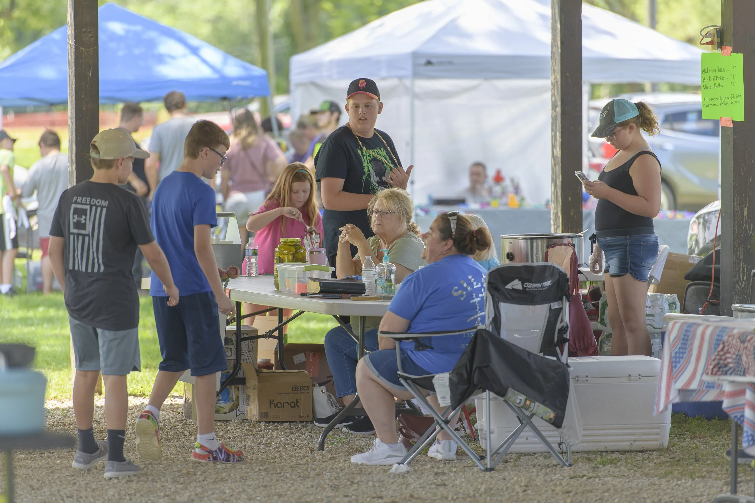 Adults and children gather around a table beneath the pavilion at the 2022 Silex Festival.