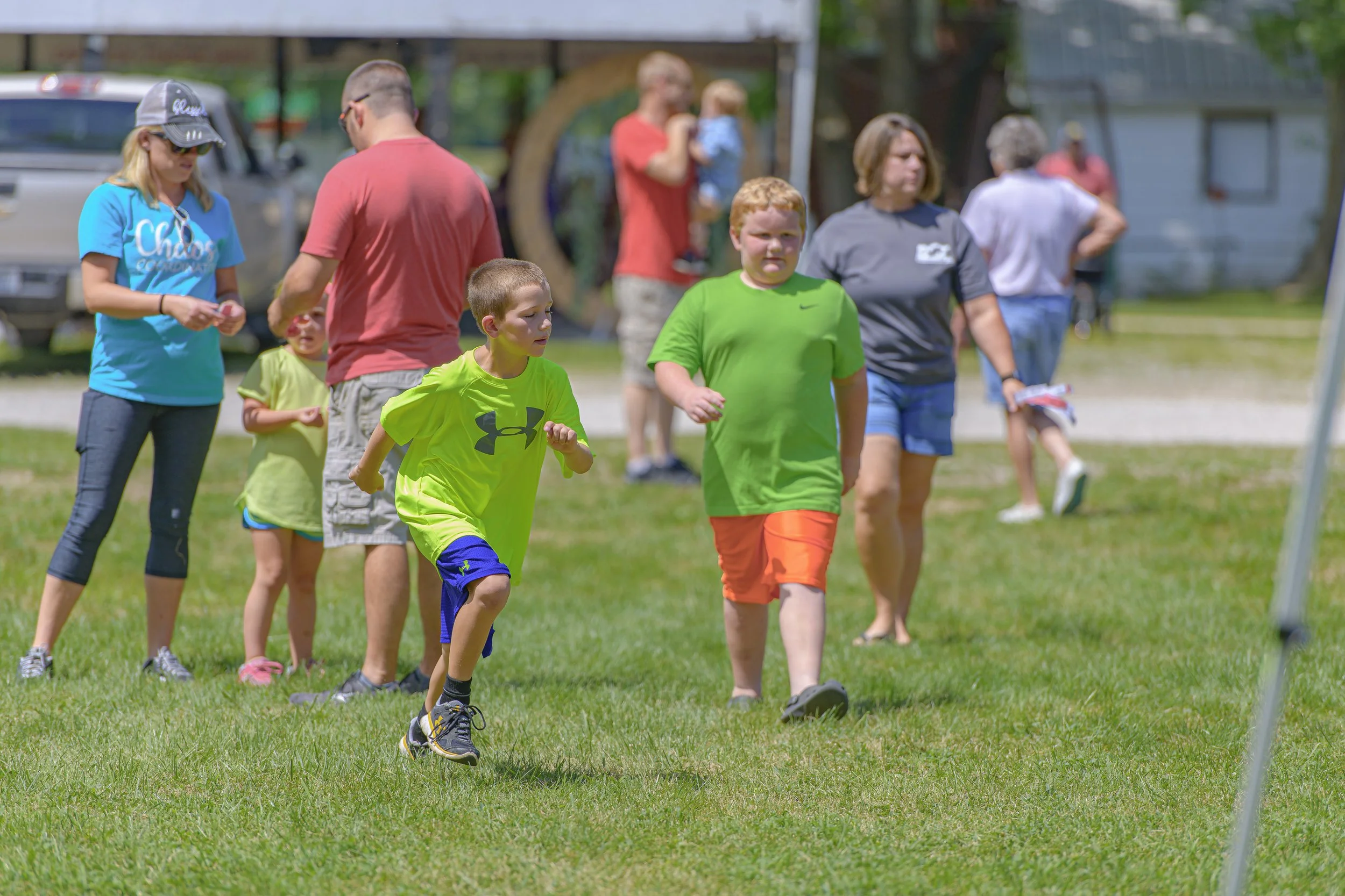 Children cross the grass near the festival tents at the 2022 Silex Festival.