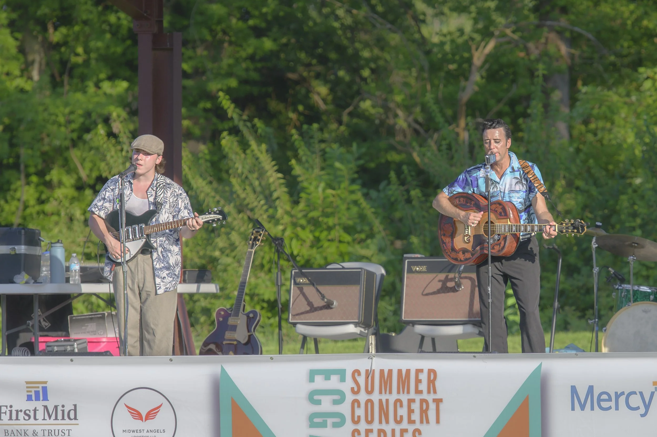 Two guitarists perform side by side on the pavilion stage, with amplifiers behind them at the 2022 ECGA Concert.