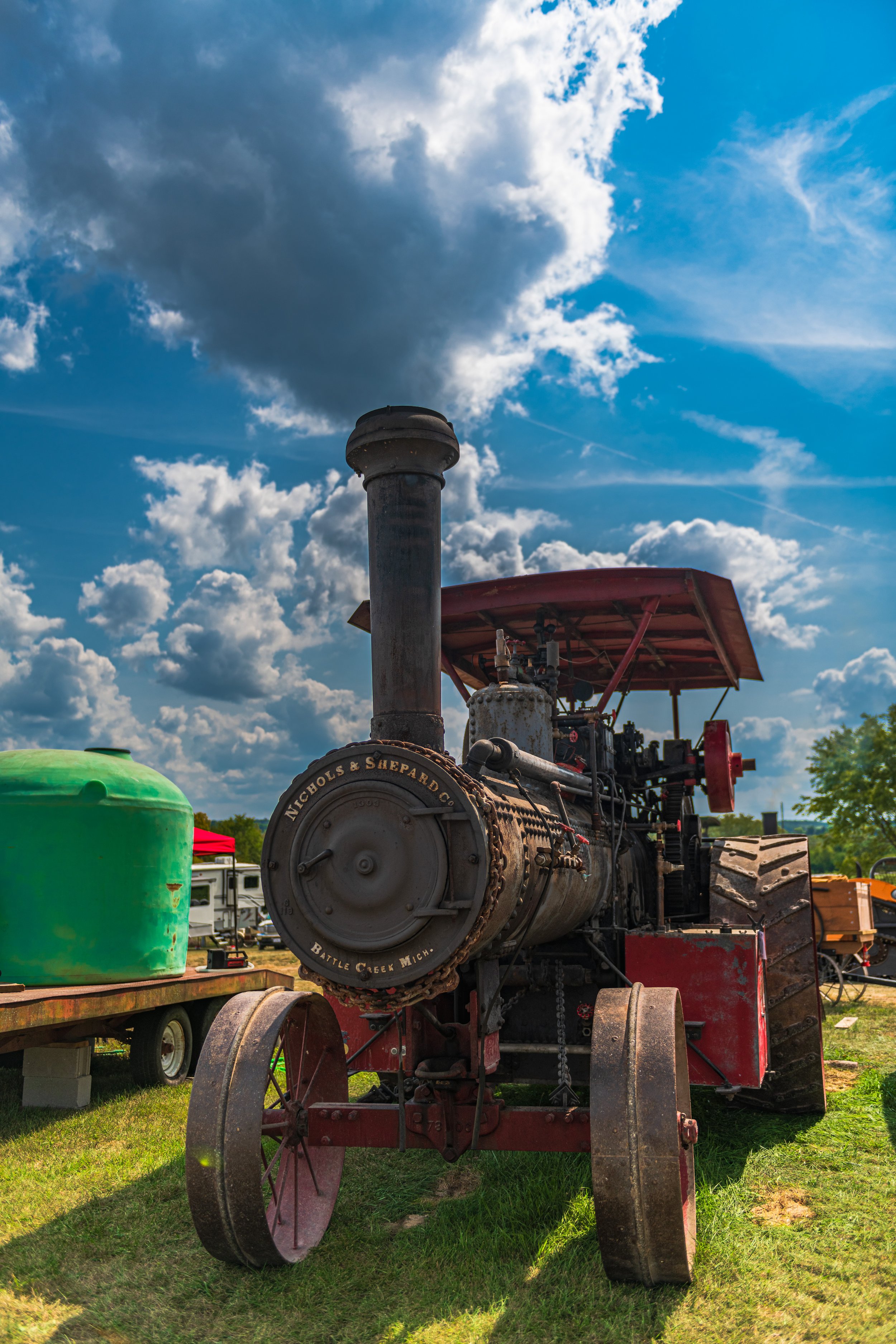 A steam traction engine stands on grass beneath a partly cloudy sky at the 2022 Old Thresher Days.