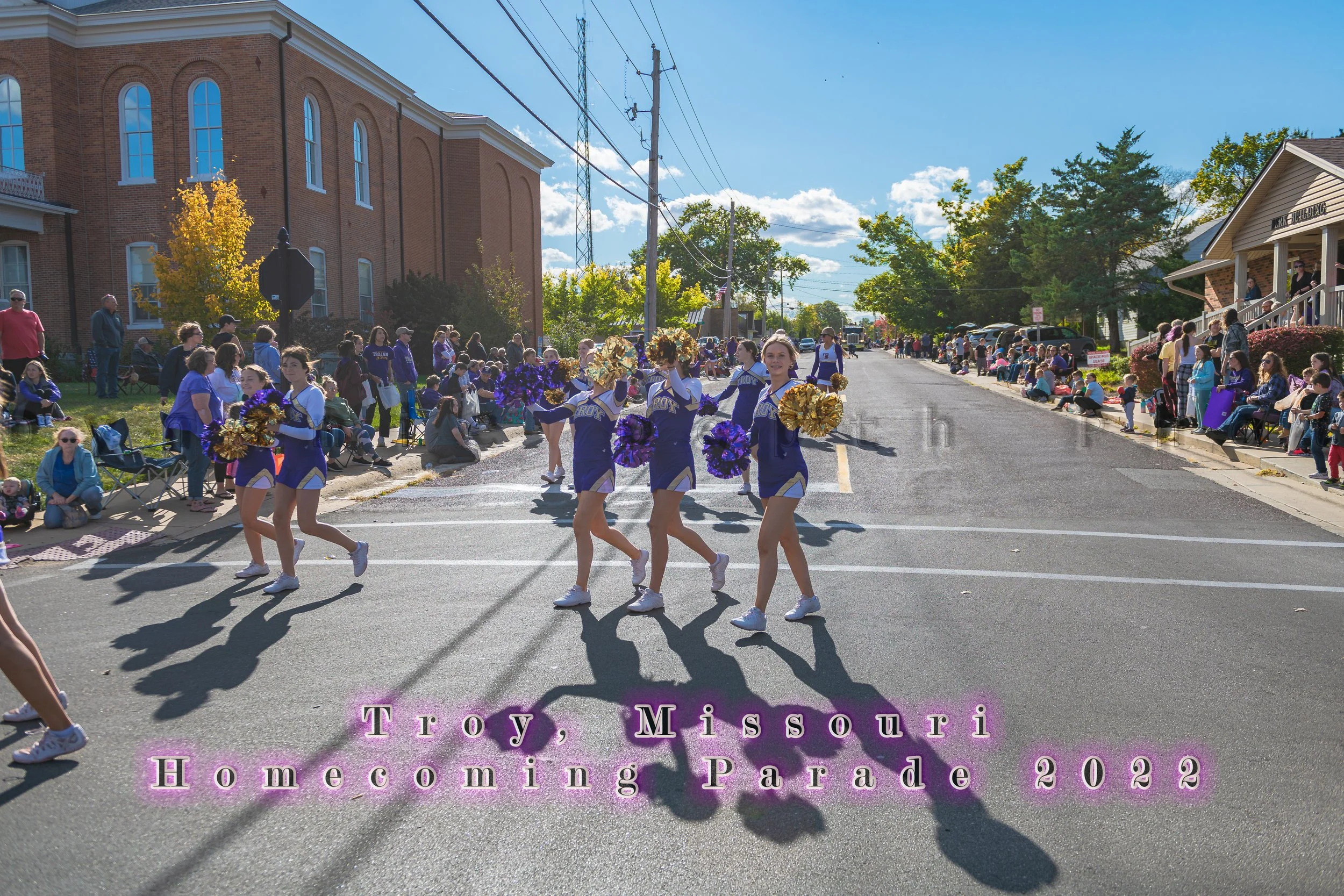Cheerleaders spread across the street as the procession continues behind them during the 2022 Troy Homecoming Parade.