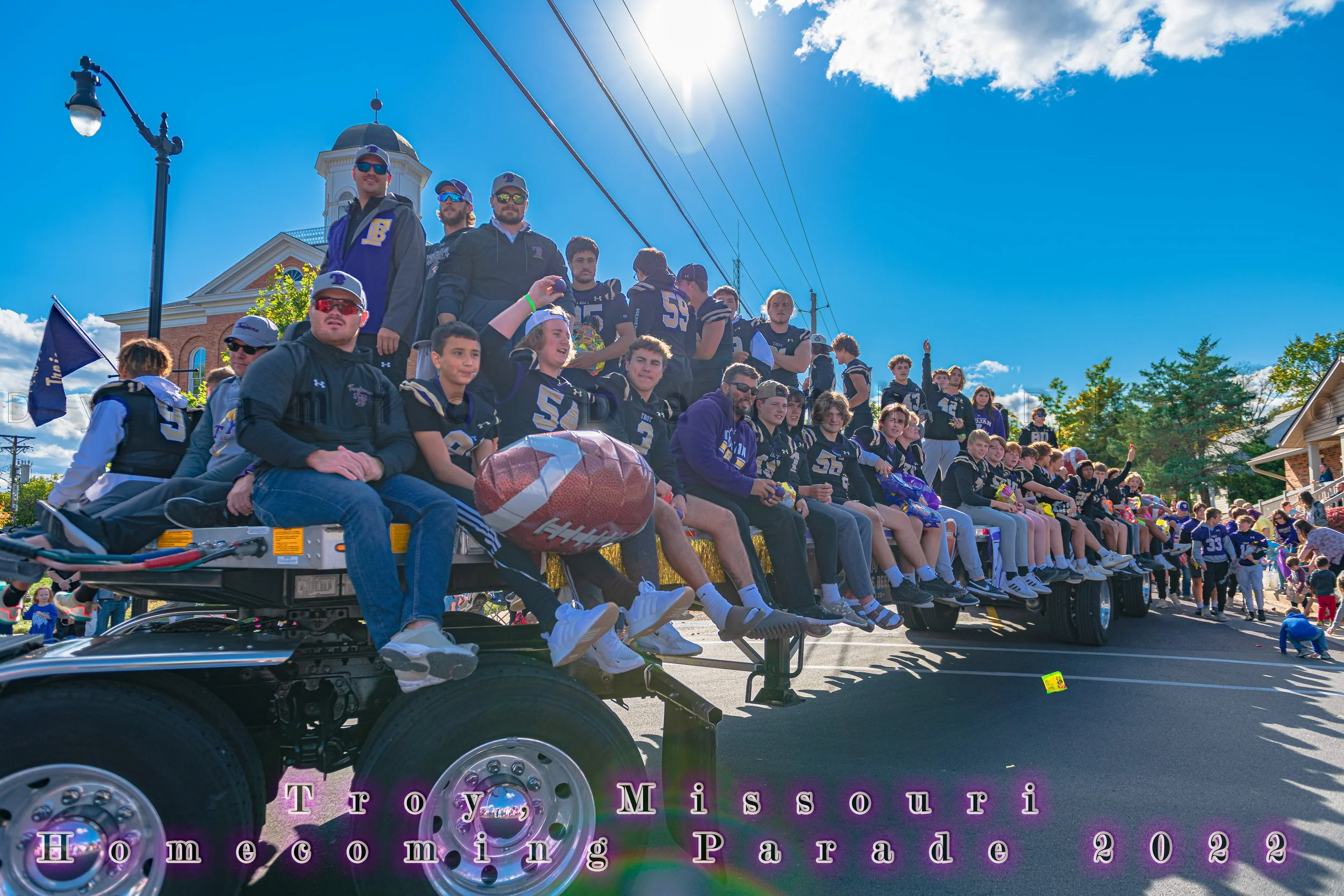 Football players ride together on a decorated flatbed float during the 2022 Troy Homecoming Parade.