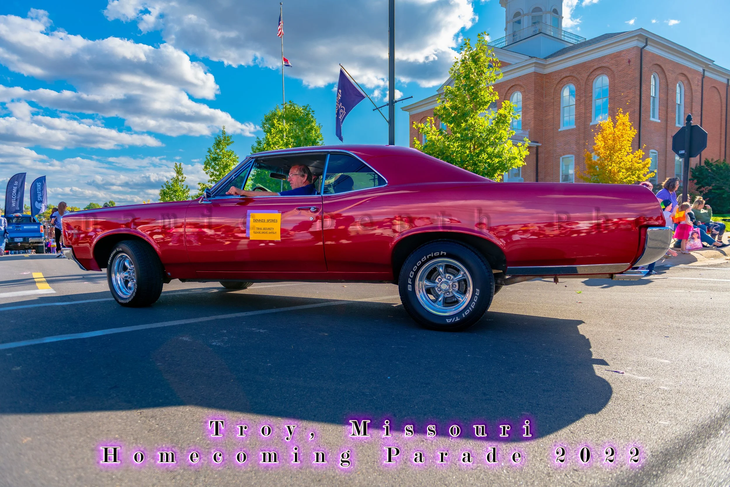 A red classic coupe-utility vehicle passes the roadside crowd during the 2022 Troy Homecoming Parade.