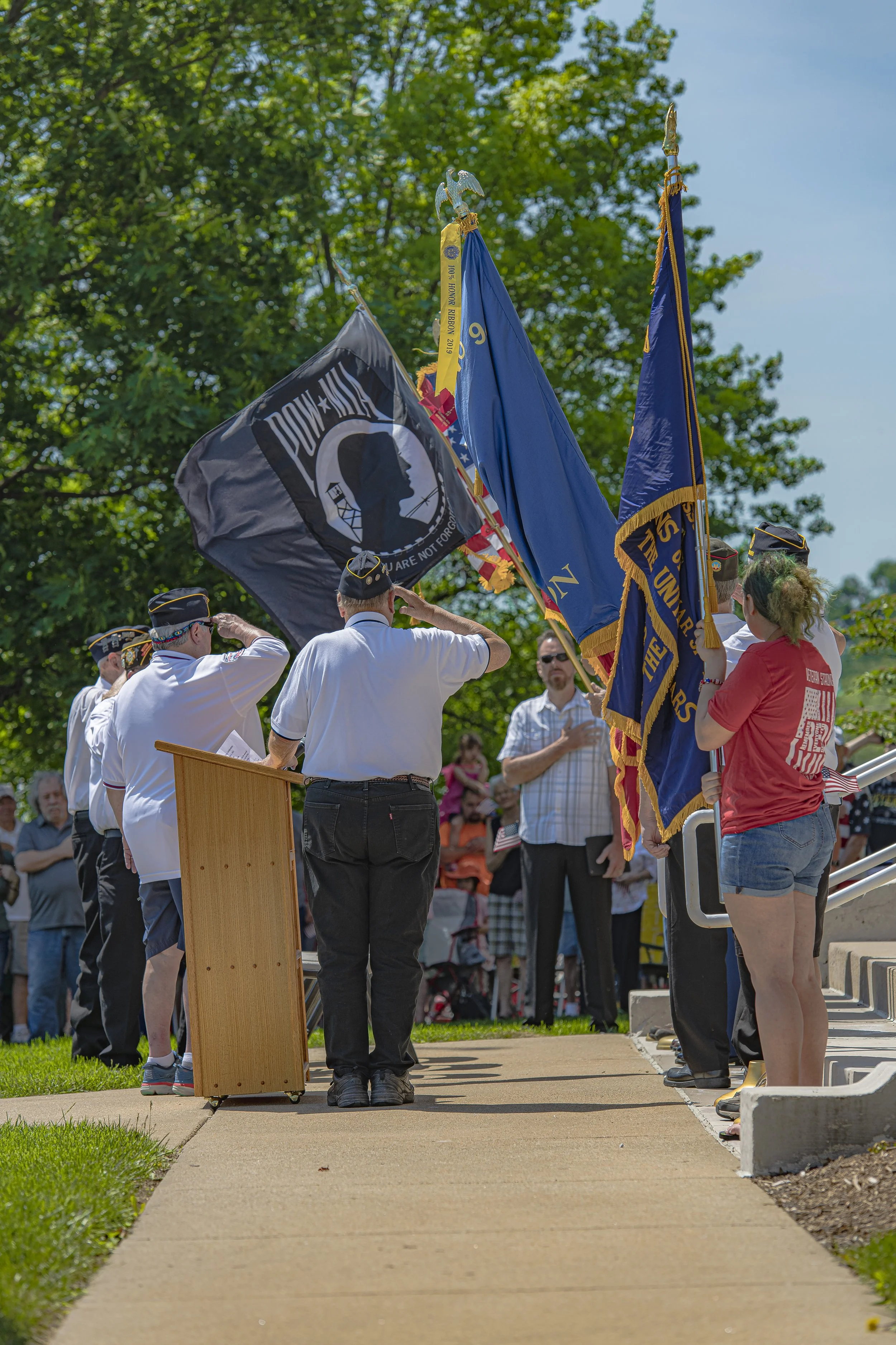 Participants salute beside the lectern and standing flags at the 2022 Lincoln County Memorial Day service.