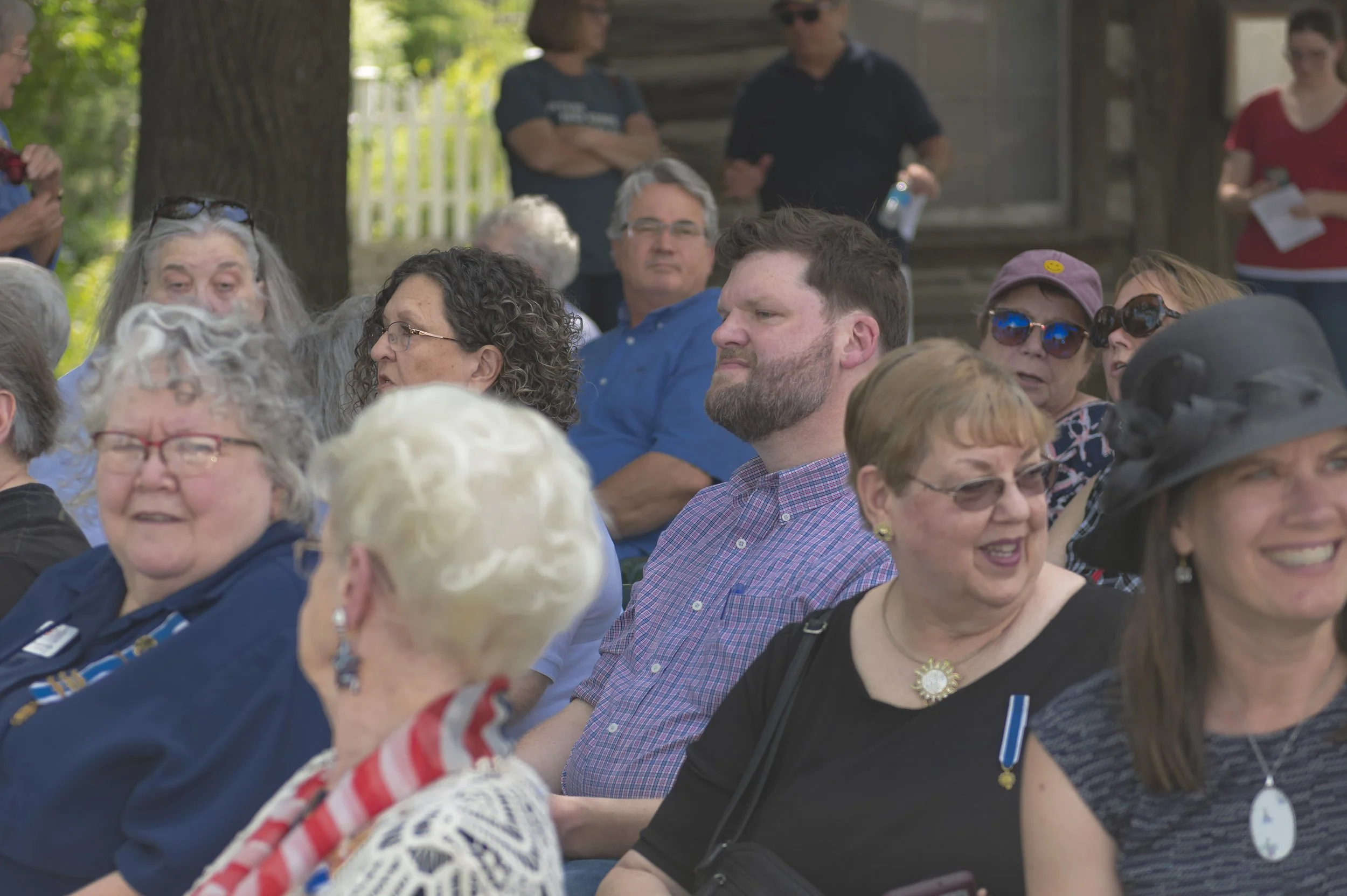 A close view shows guests seated beneath the trees at the 2022 Daughters of the American Revolution ceremony.