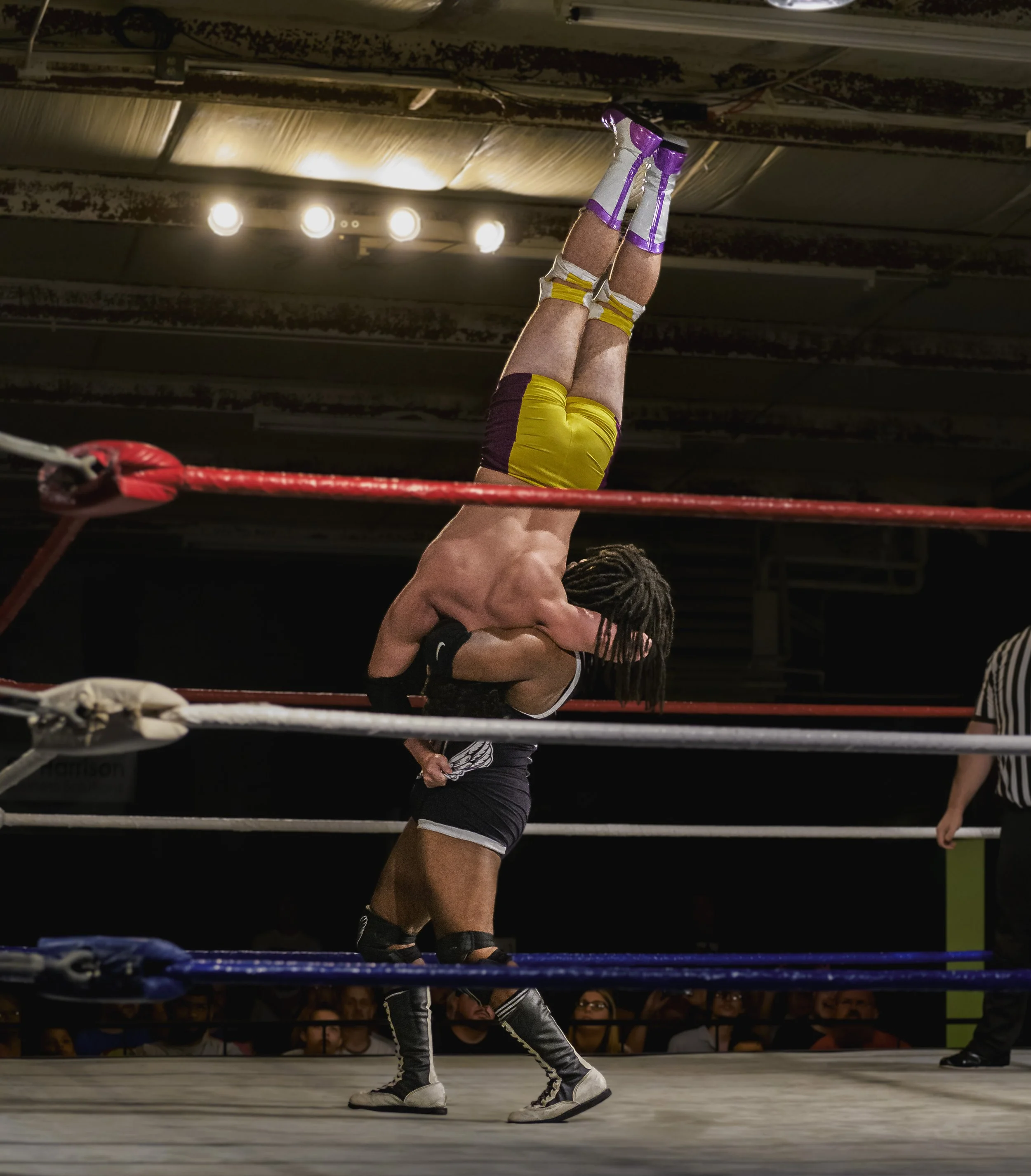 A wrestler holds an opponent upside down above the mat at the 2022 World League Wrestling event.