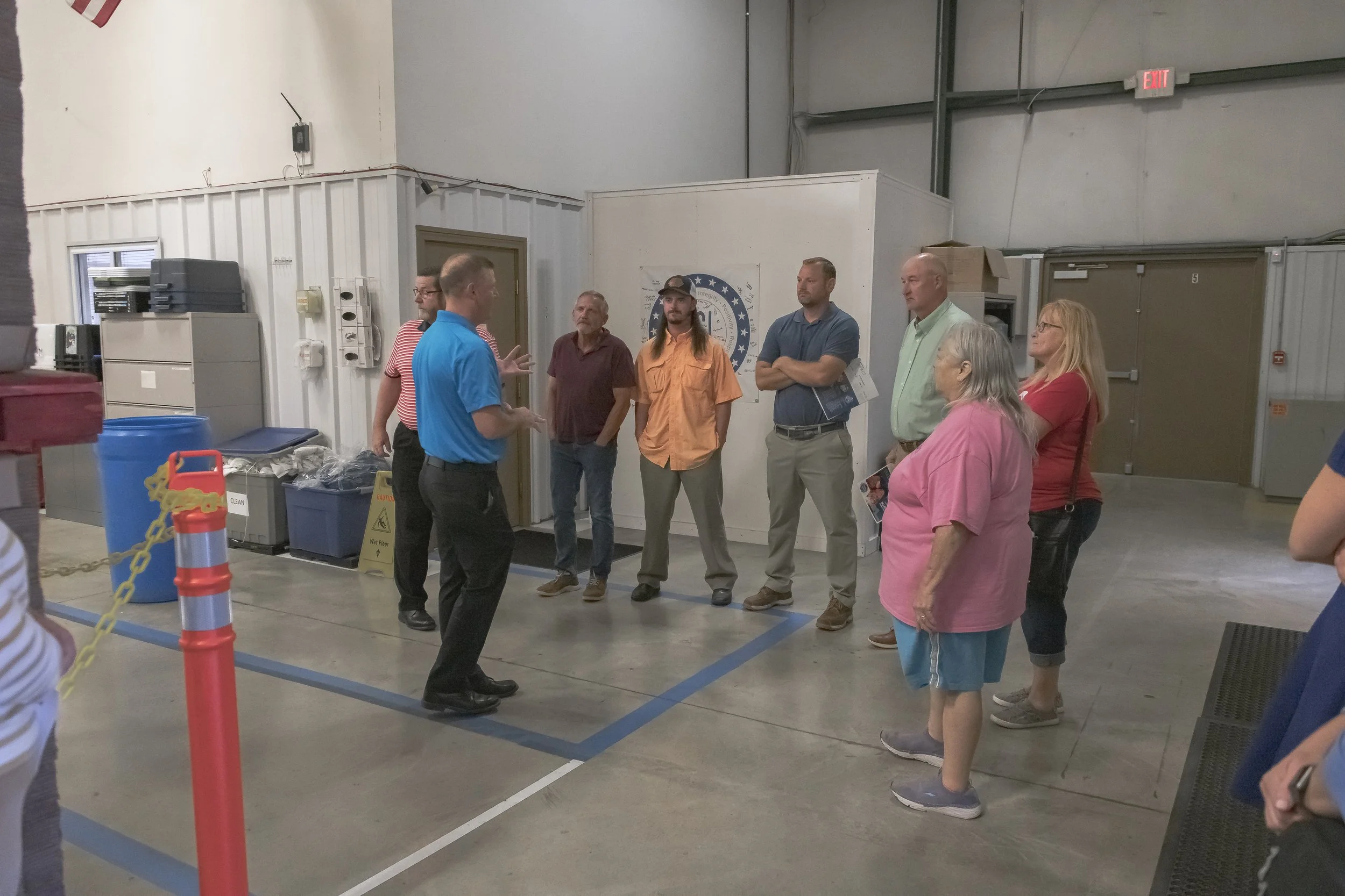 A guide in a blue shirt addresses visitors on the production floor at the 2022 BCI Open House.