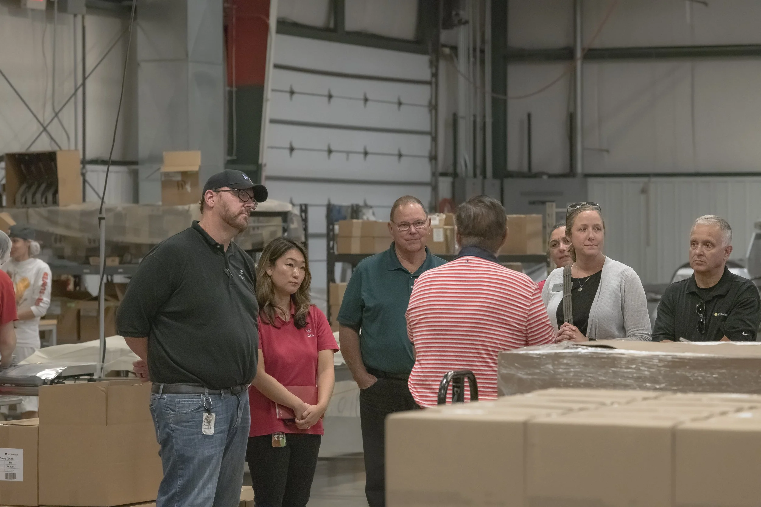 Tour participants listen beside stacks of cartons at the 2022 BCI Open House.