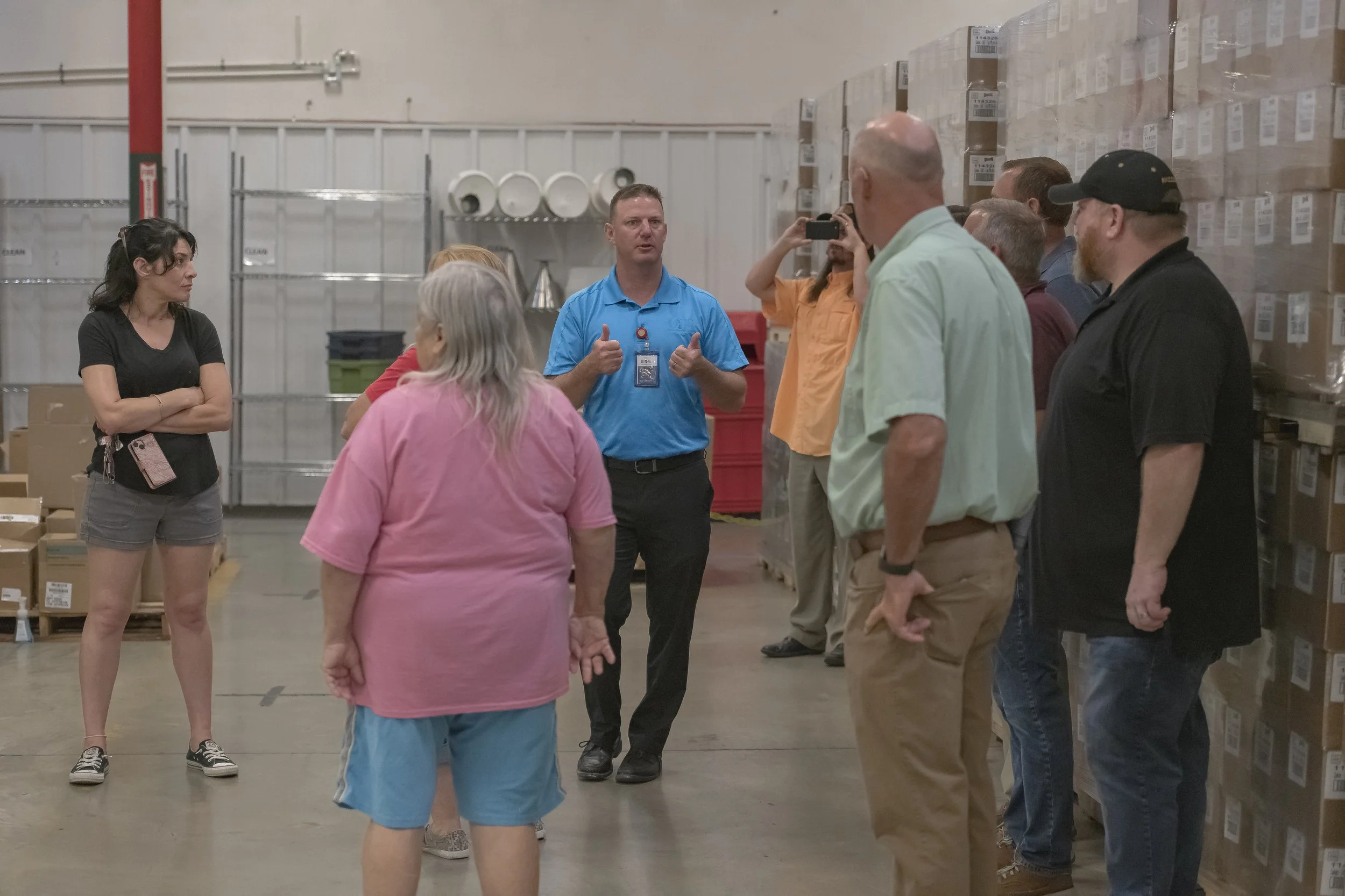 A guide gestures while speaking to visitors on the production floor at the 2022 BCI Open House.