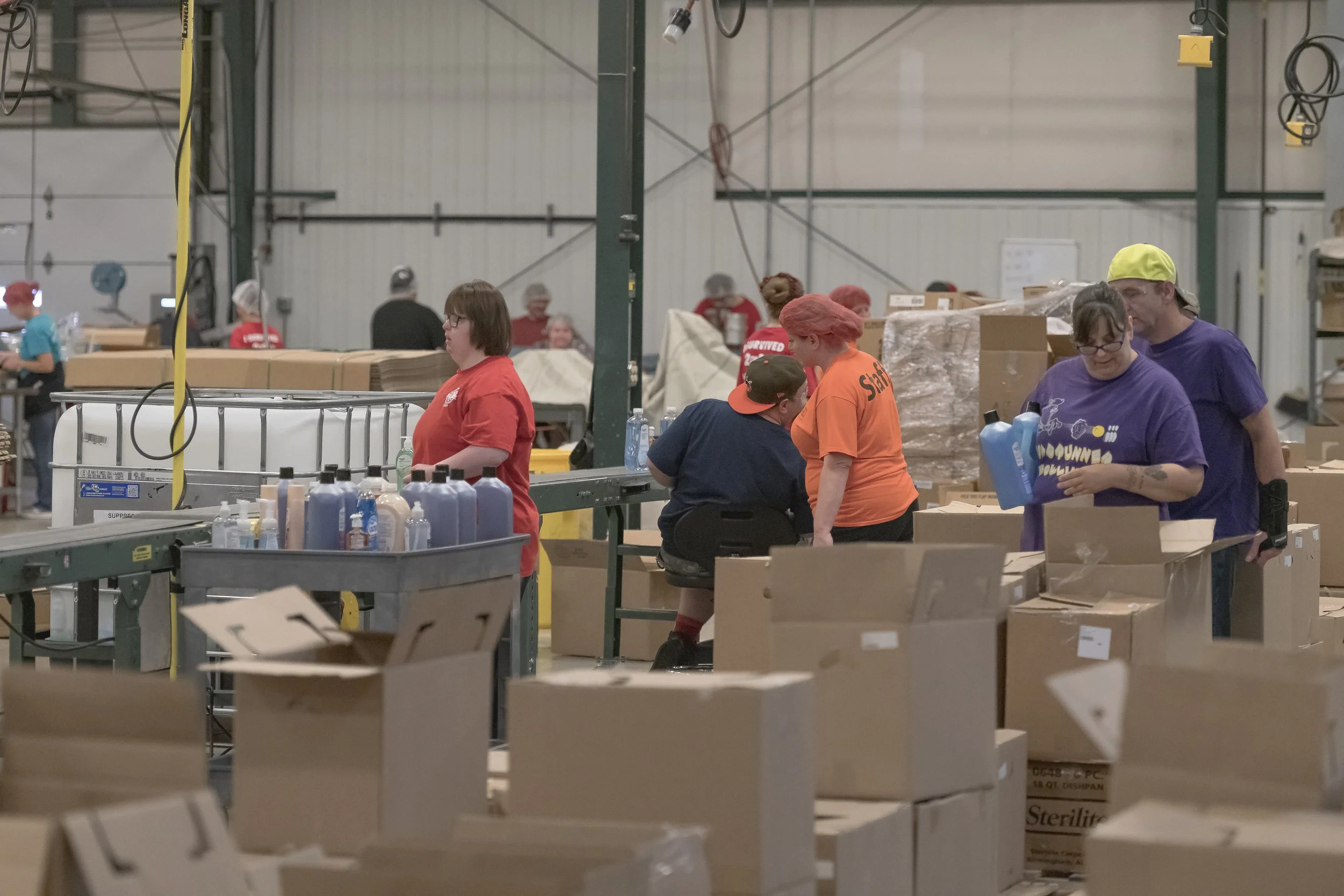 Workers handle bottles and cartons along a production line at the 2022 BCI Open House.