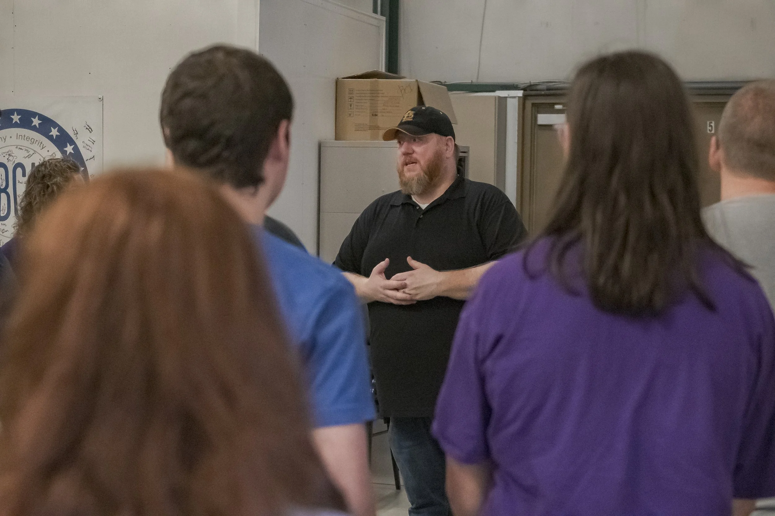 A speaker in a black cap addresses a group of visitors at the 2022 BCI Open House.