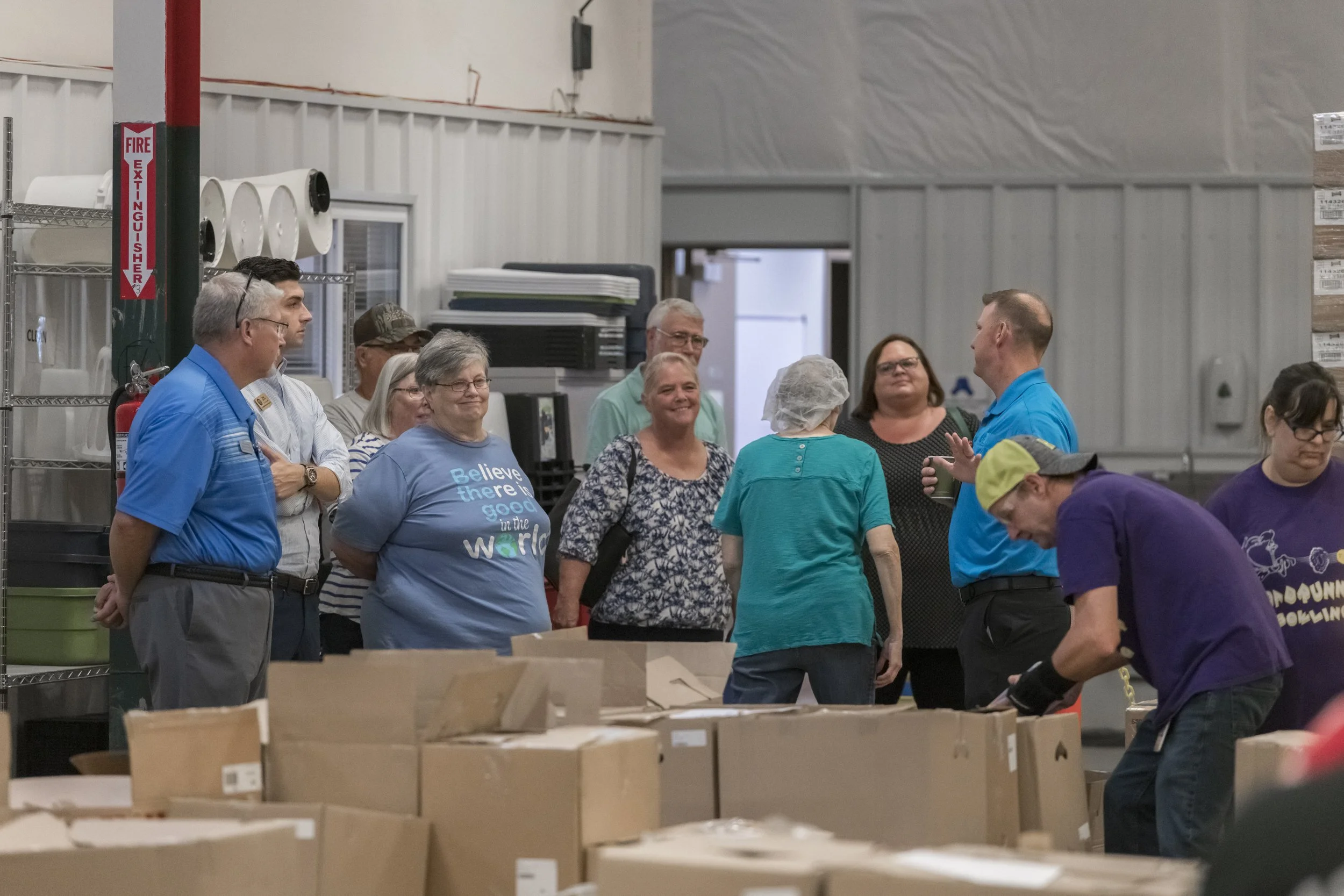 Visitors observe workers and open cartons on the production floor at the 2022 BCI Open House.