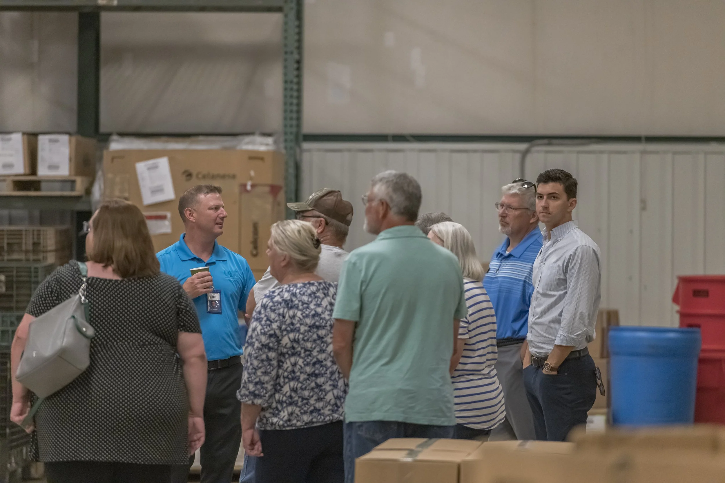 Visitors gather around a guide among stacks of boxes at the 2022 BCI Open House.