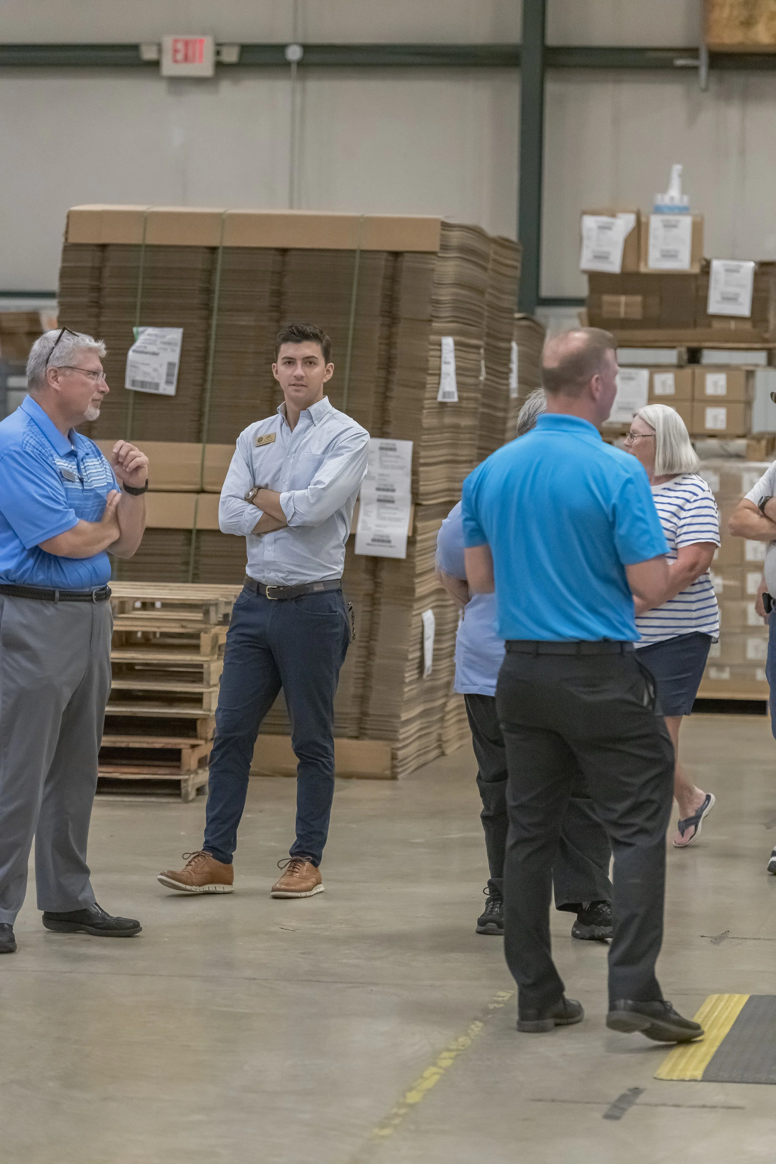 Tour participants stand beside a tall stack of flattened cartons at the 2022 BCI Open House.