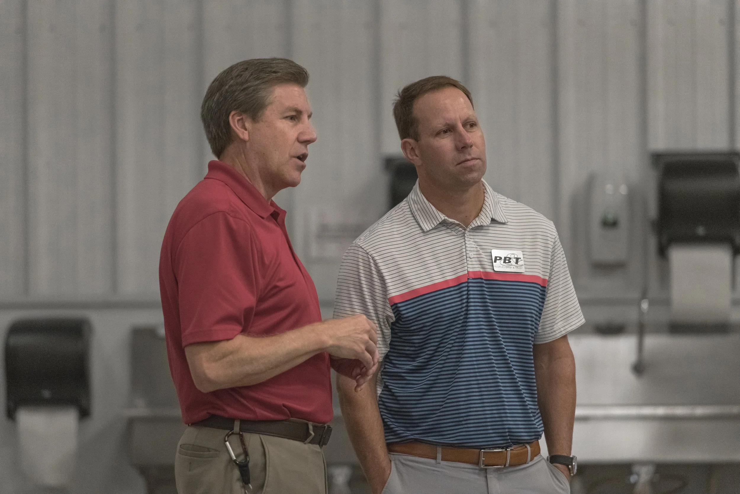 Two attendees talk beside the facility's sinks at the 2022 BCI Open House.