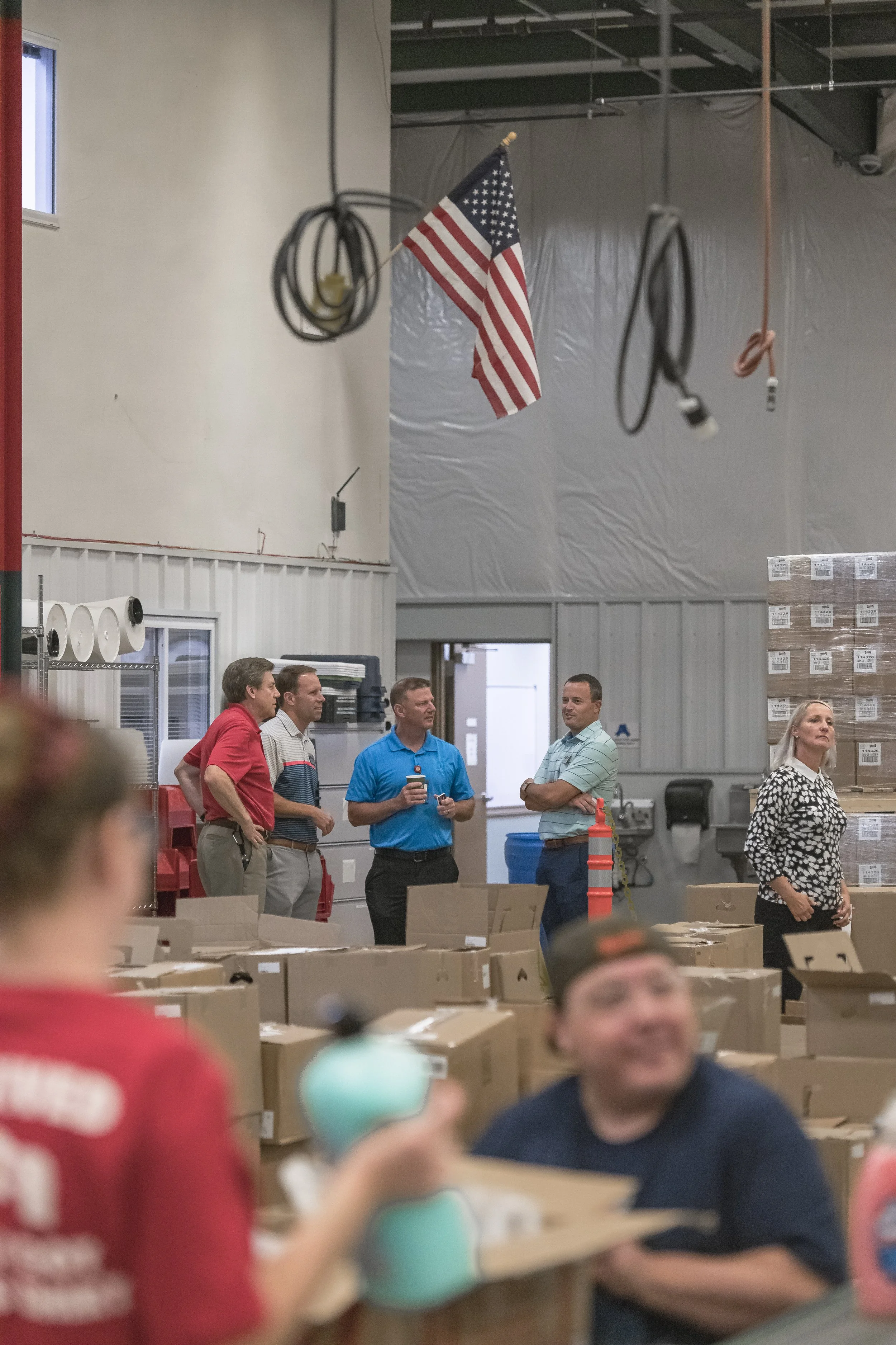 Visitors converse beneath an American flag on the production floor at the 2022 BCI Open House.